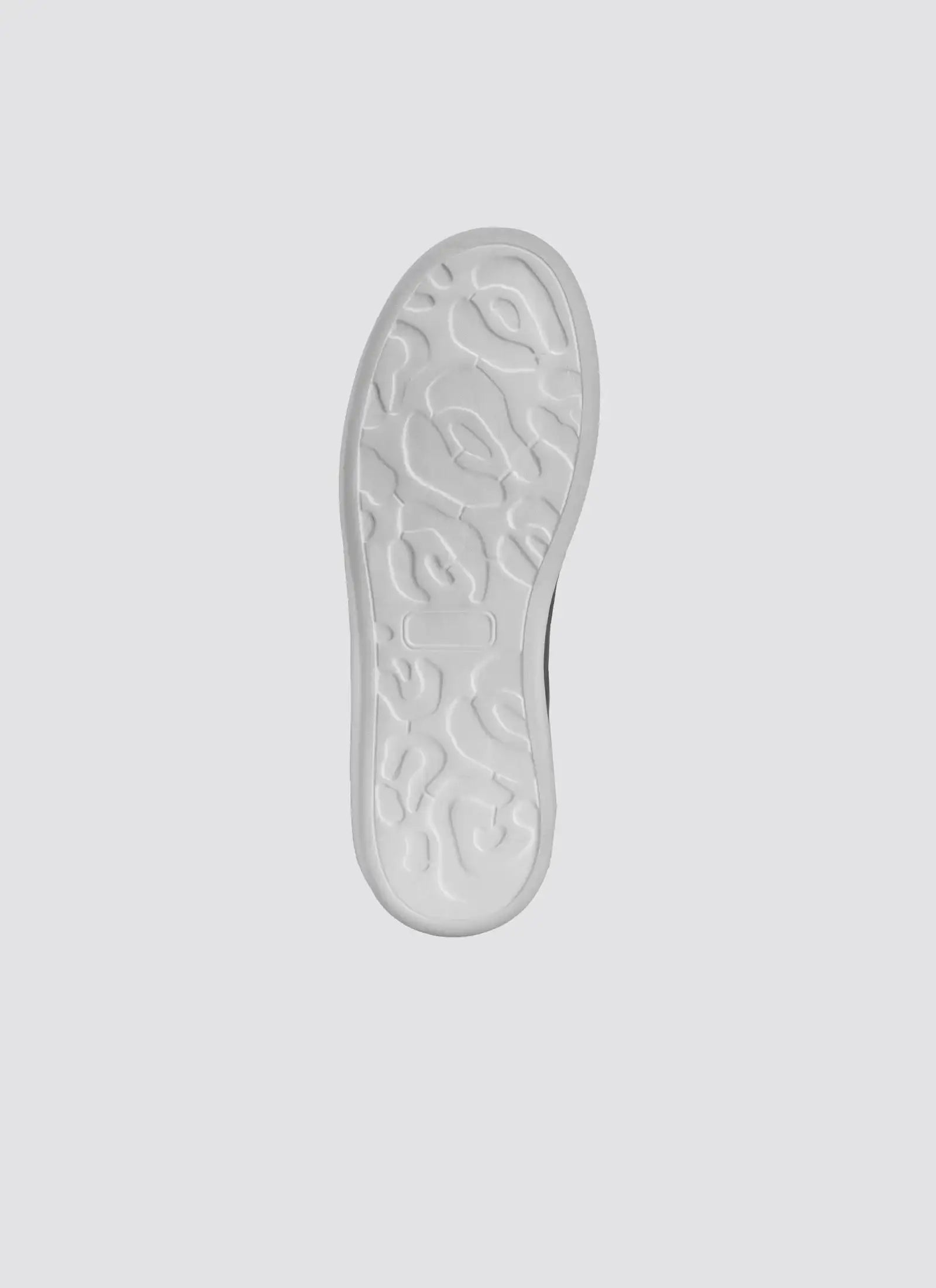 White textured shoe sole with unique abstract tread pattern on a light background