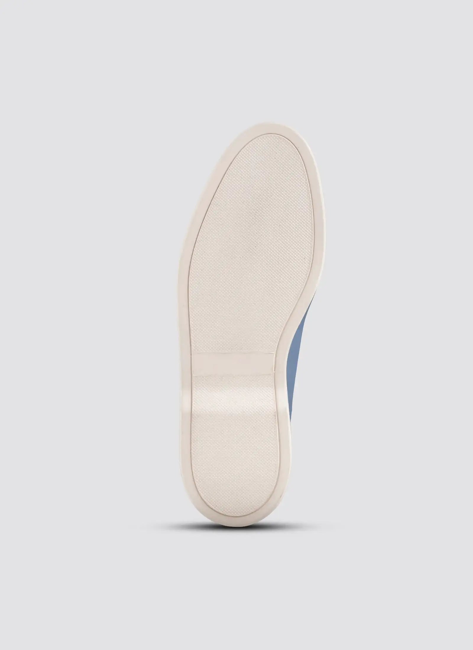 Close-up of a white shoe sole on a light gray background