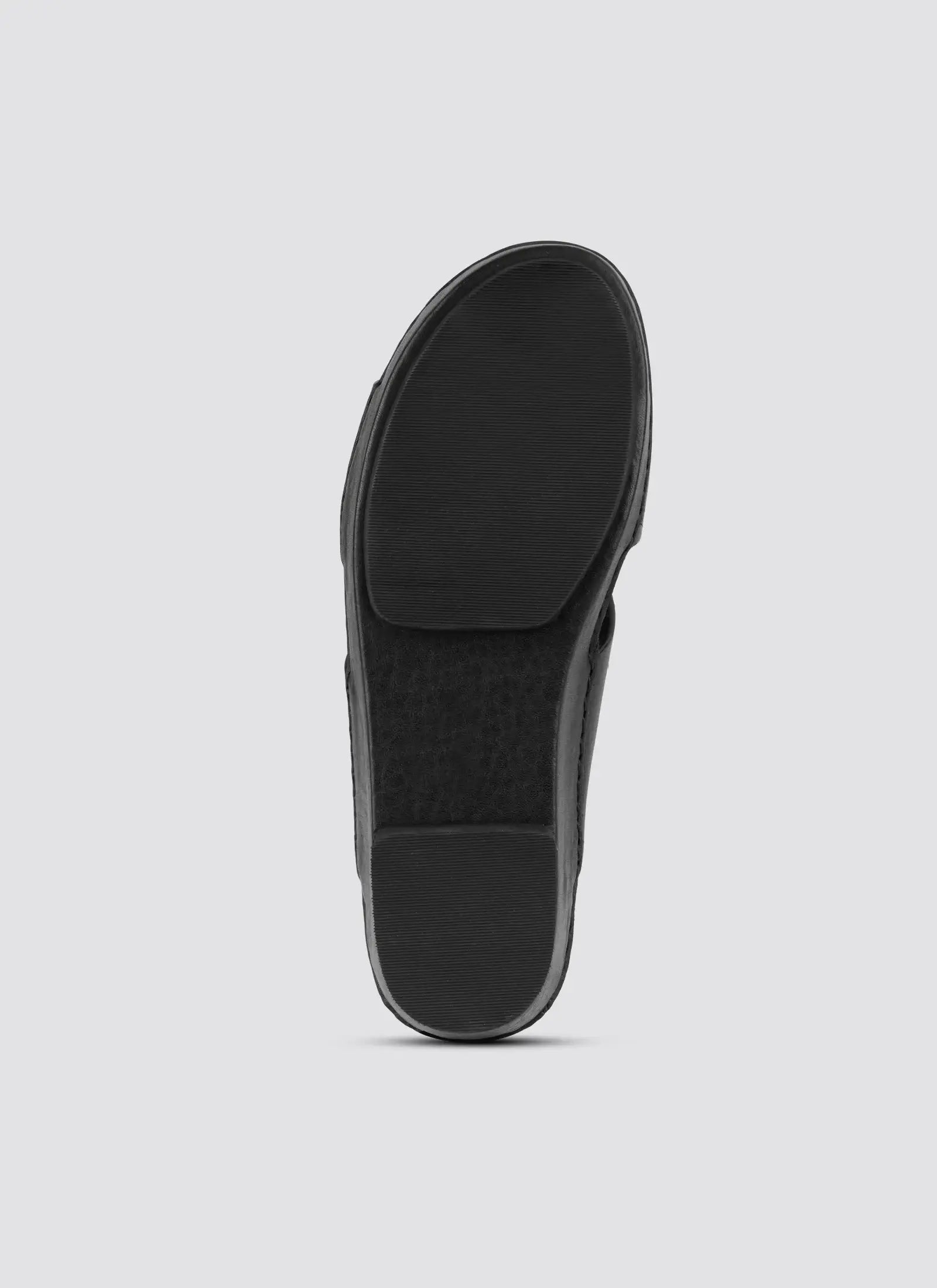 Black sandal with textured sole on a light gray background