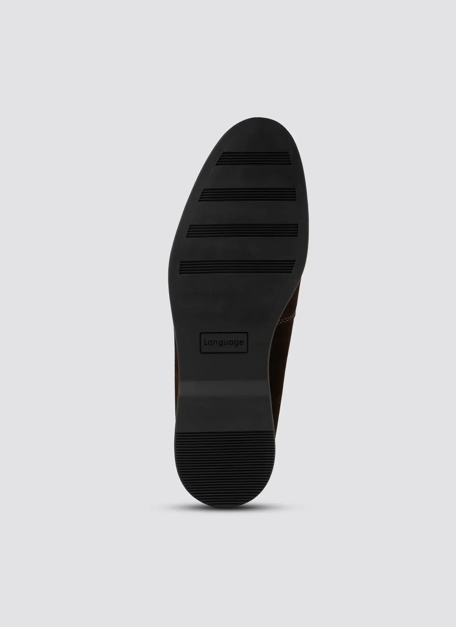 Close-up of black rubber dress shoe sole with grip patterns on a light background
