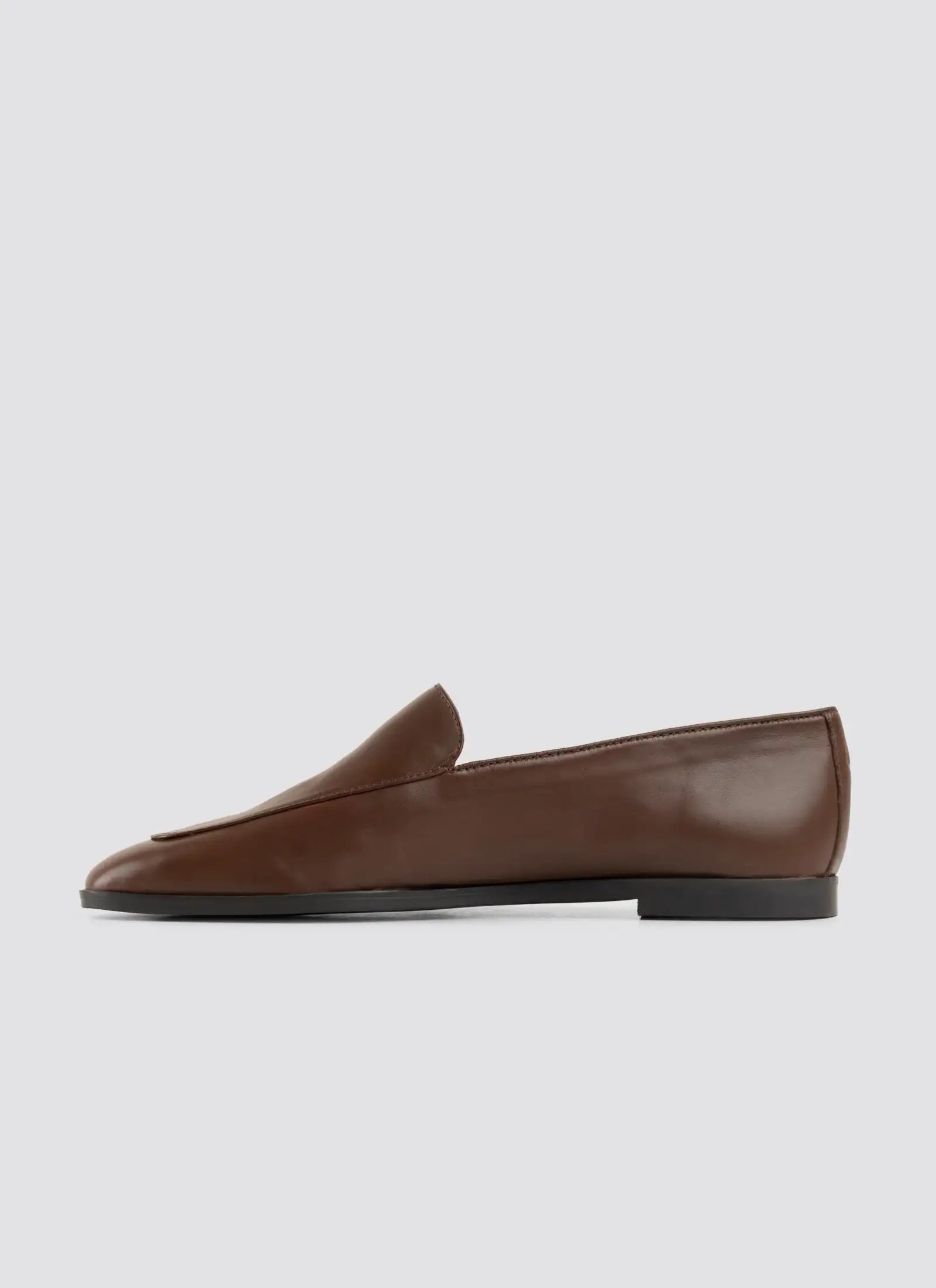 Brown loafer shoe on a light gray background