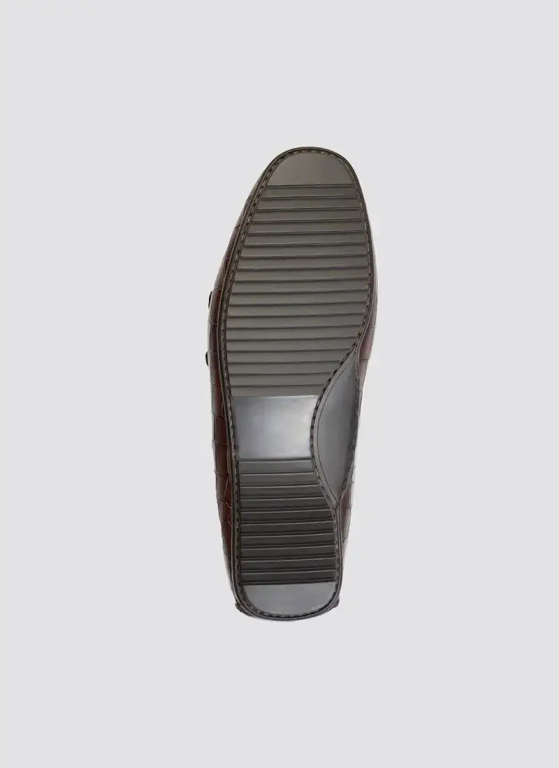Brown men's loafer shoe sole with textured rubber grip, formal footwear detail