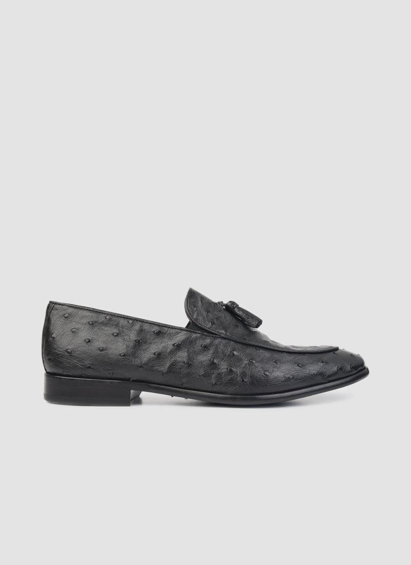 Men's black textured leather loafer with tassel detail on white background