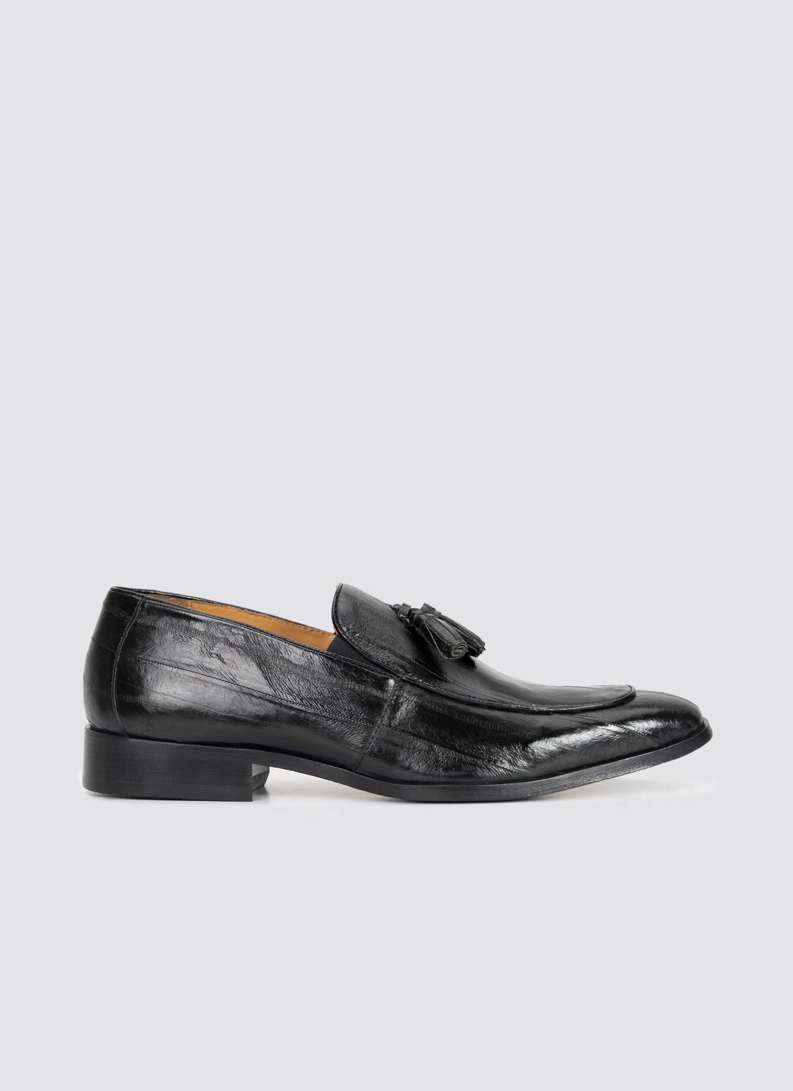 Men's black leather tassel loafer with low heel, classic formal footwear on white background