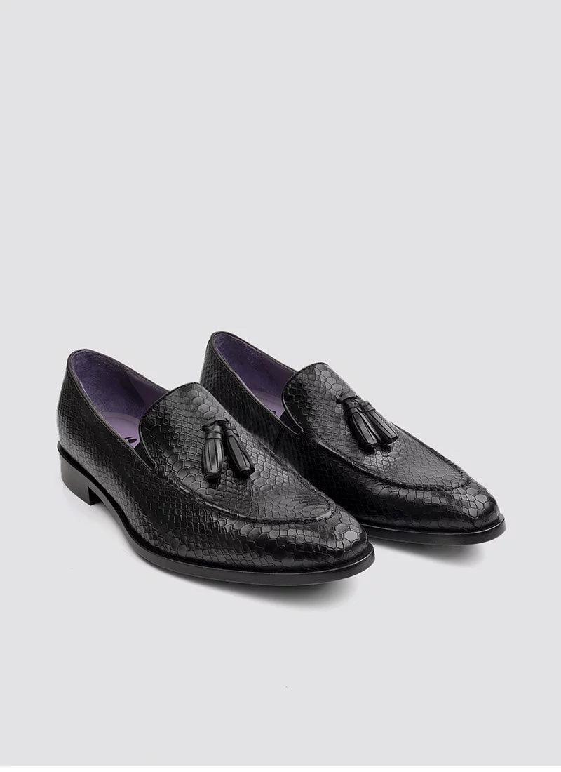 Black textured leather tassel loafers for men with purple lining on a white background