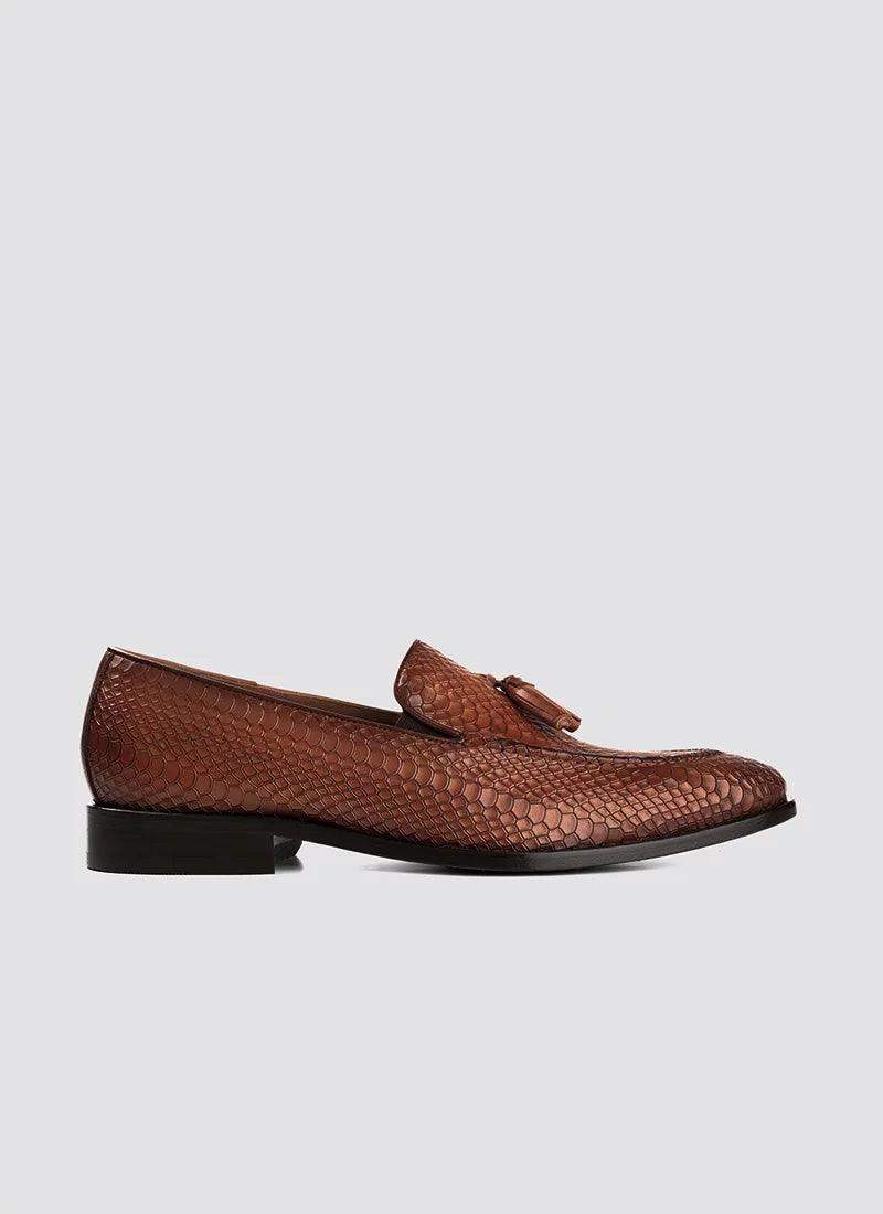 Tan textured leather loafer with tassel, men's dress shoe on white background