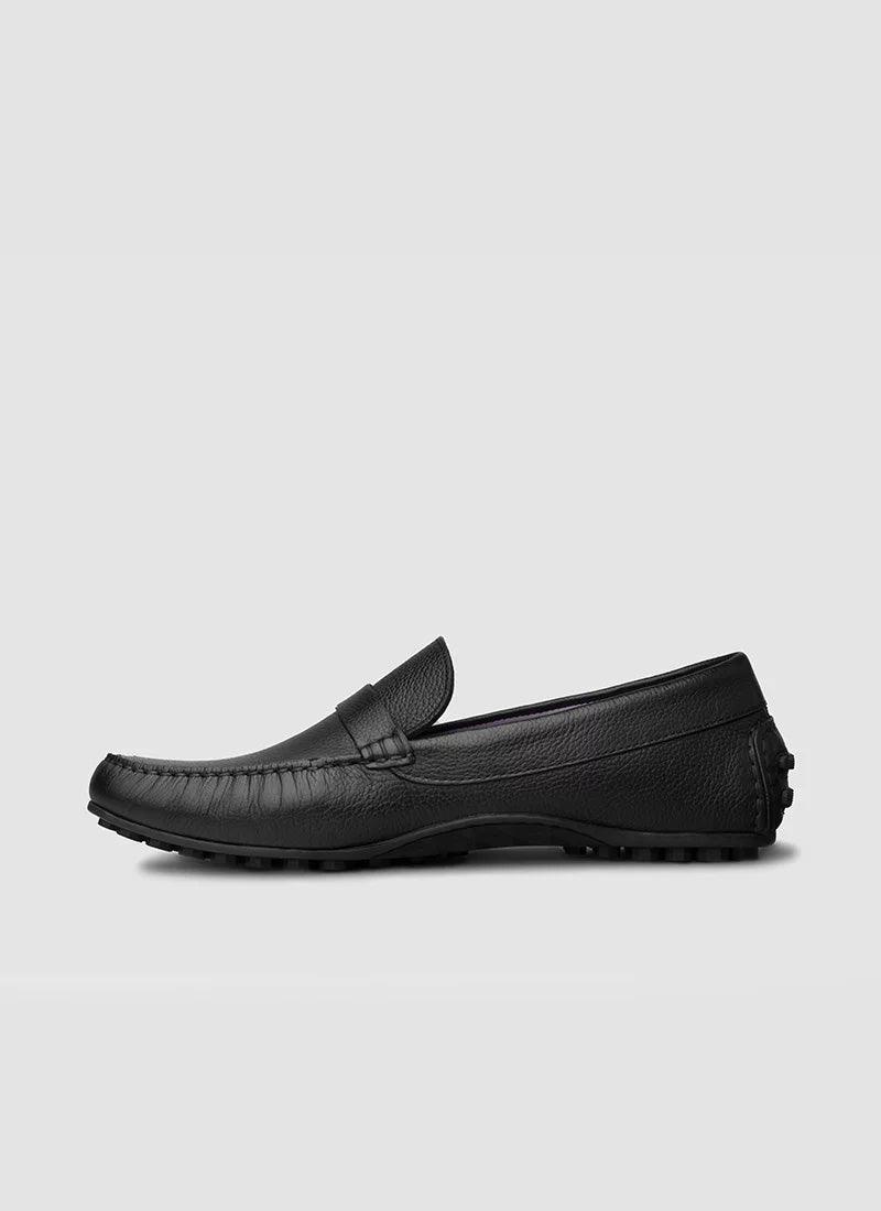 Black leather loafer for men with textured sole, side view on plain background