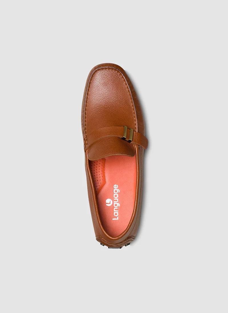 Tan leather loafer with buckle detail and orange insole, top view on neutral background