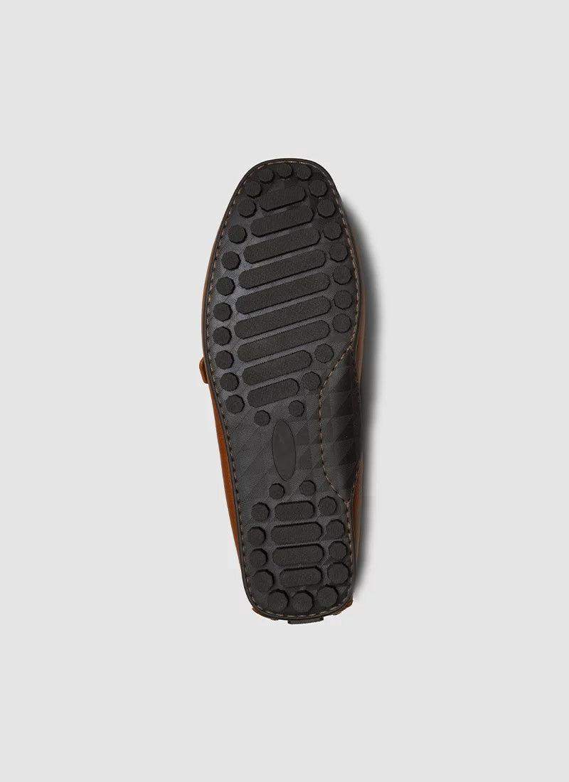 Brown loafer shoe with textured black rubber sole, premium men's footwear closeup
