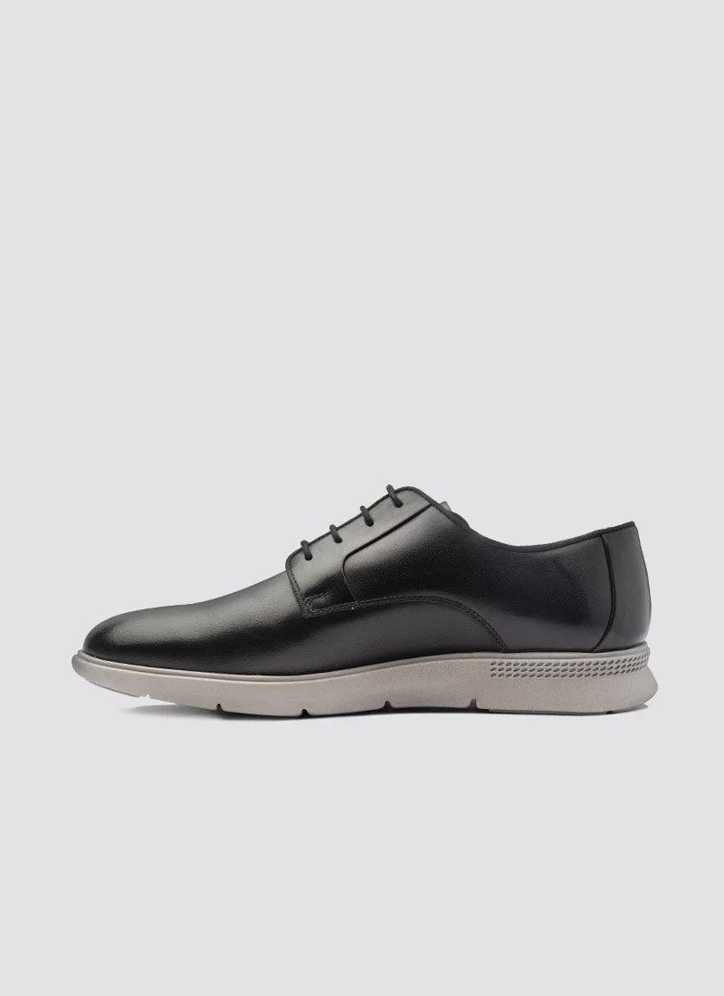 Men's black leather lace-up dress shoe with white rubber sole, side profile on white background