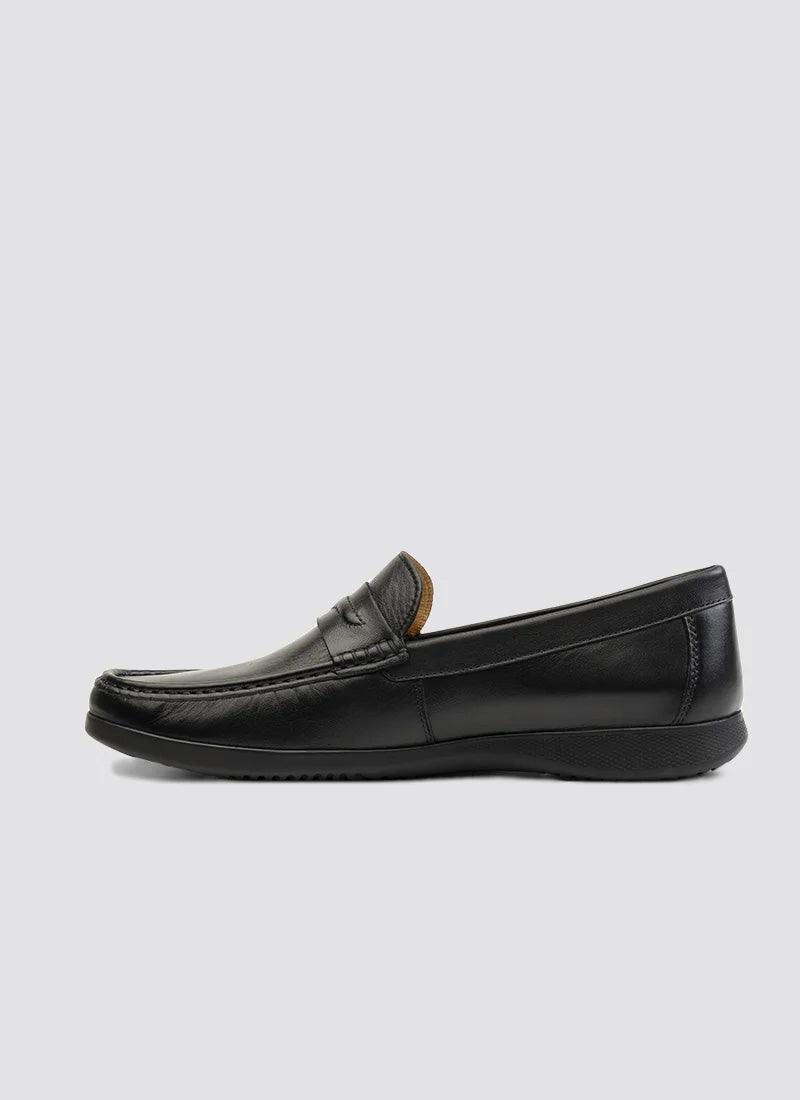 Black leather men's loafer with moc toe design and slip-on style on a light background.