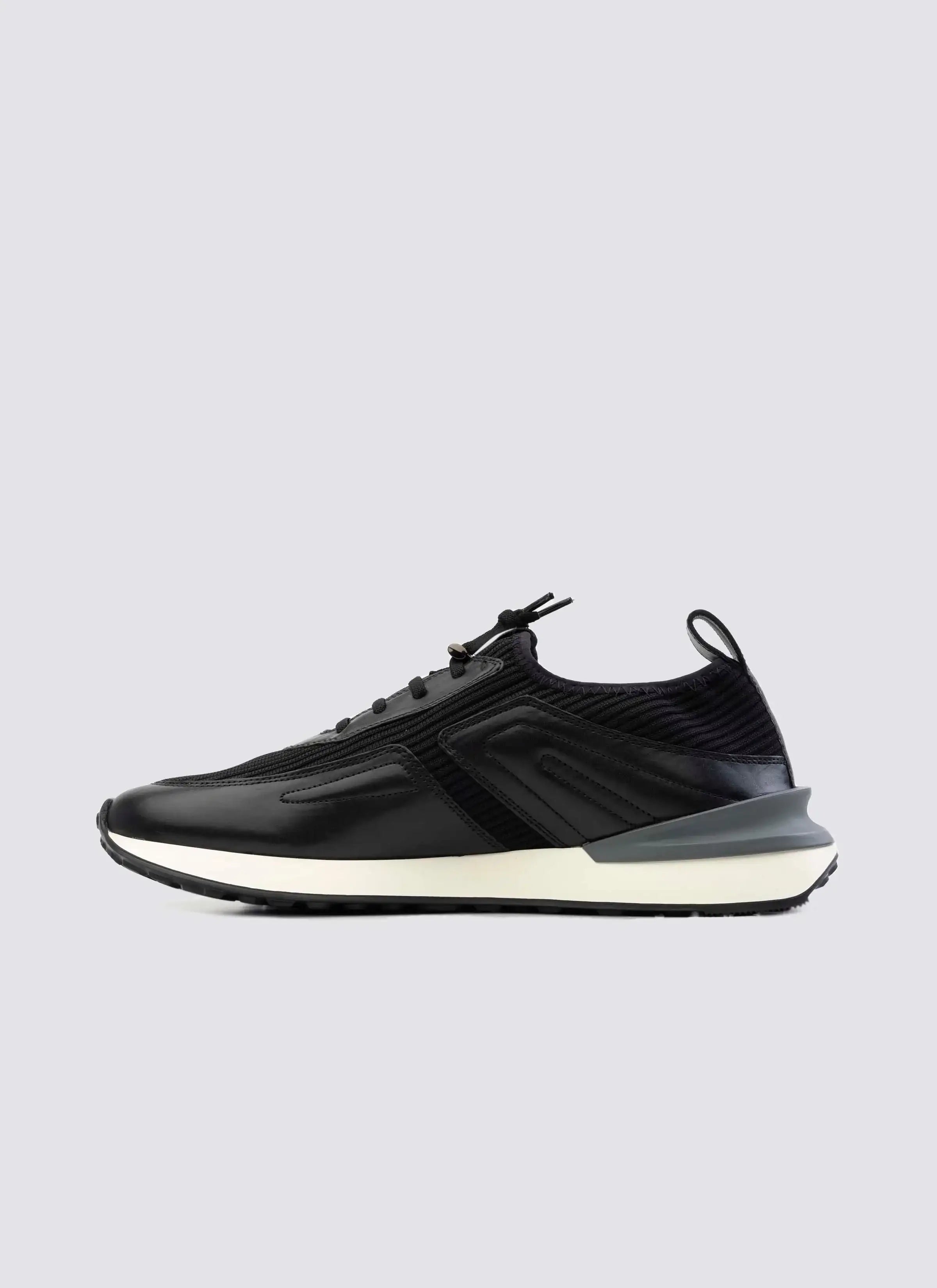 black men's sneaker with white sole, side view, modern athletic footwear on white background
