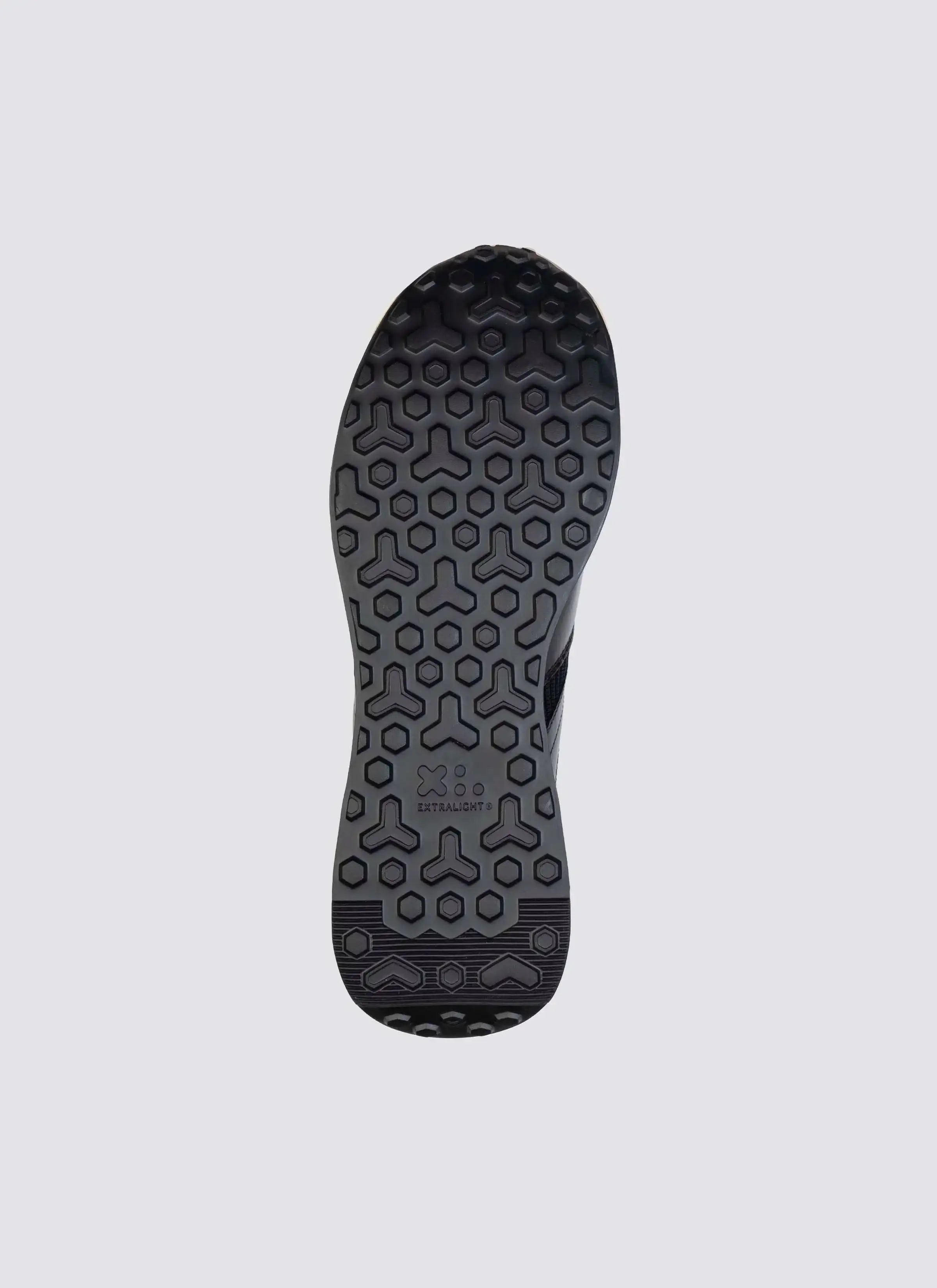 Black shoe sole with hexagonal tread pattern and 'Extralight' branding, isolated on white background