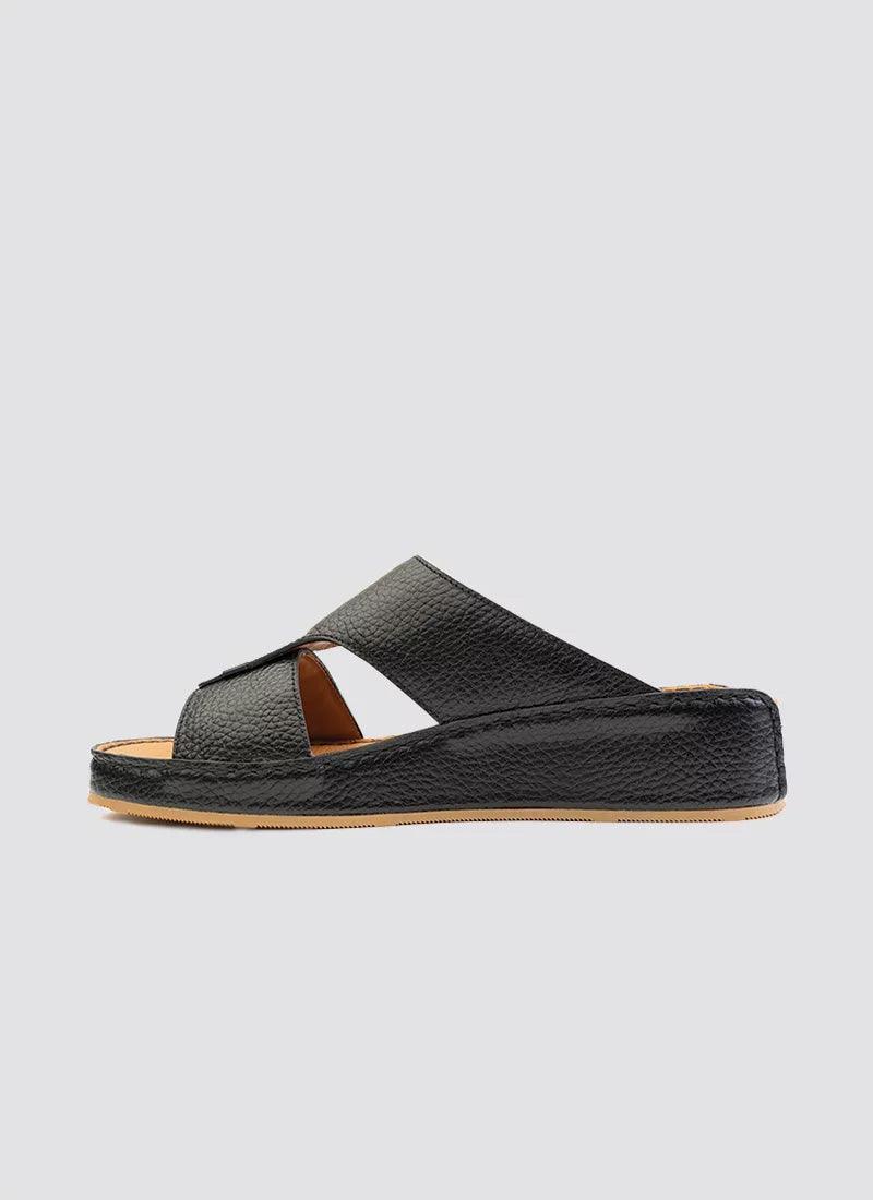 Black leather slide sandal with criss-cross straps and flat tan sole for men or women