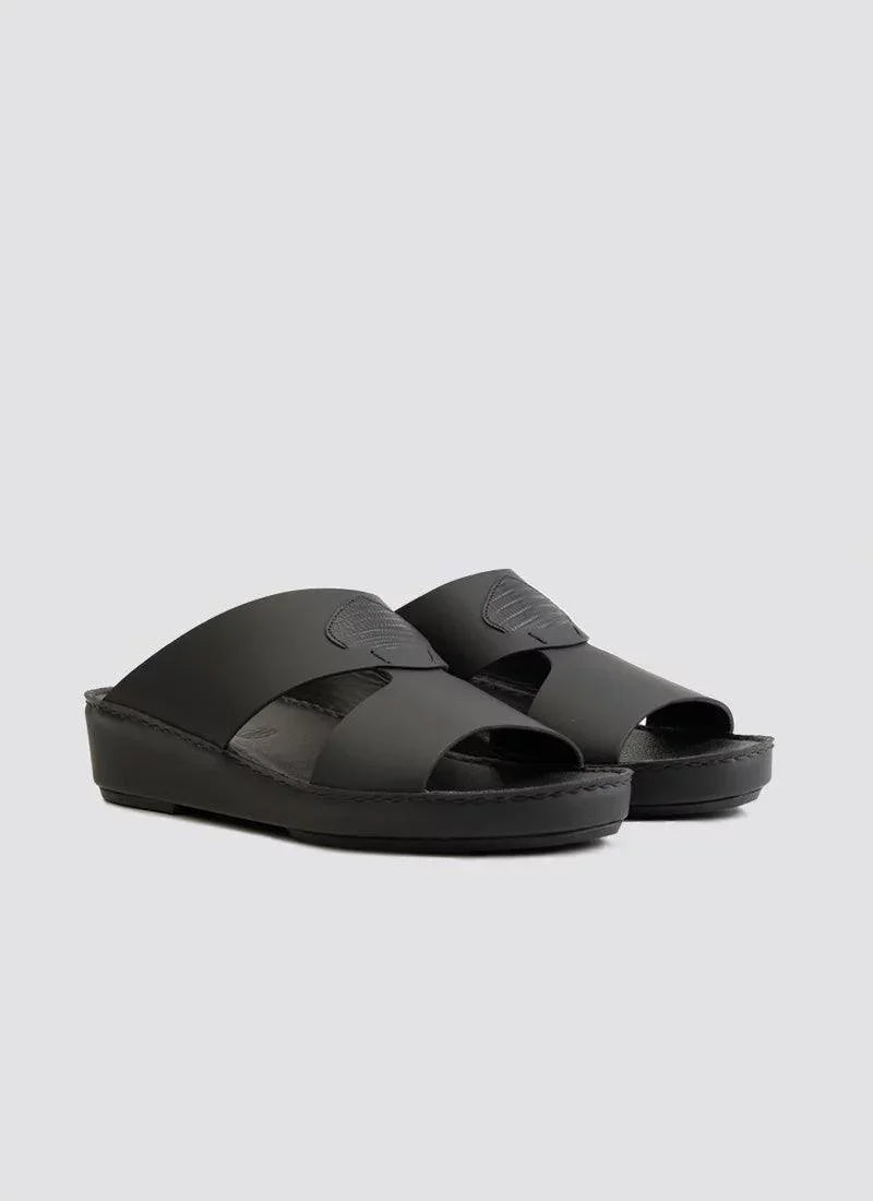 Black men's leather slip-on sandals with open toe and cut-out strap design on a gray background