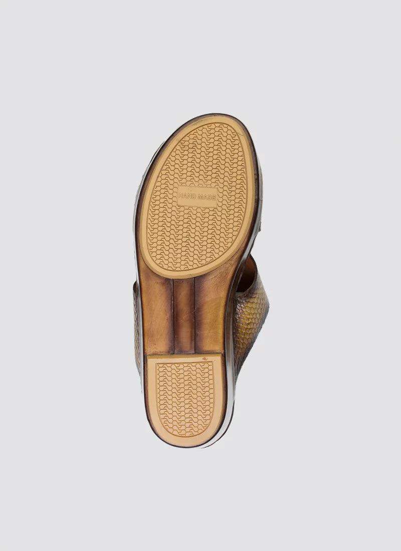 Tan woven leather shoe with textured rubber sole and 'Hand Made' label, viewed from below