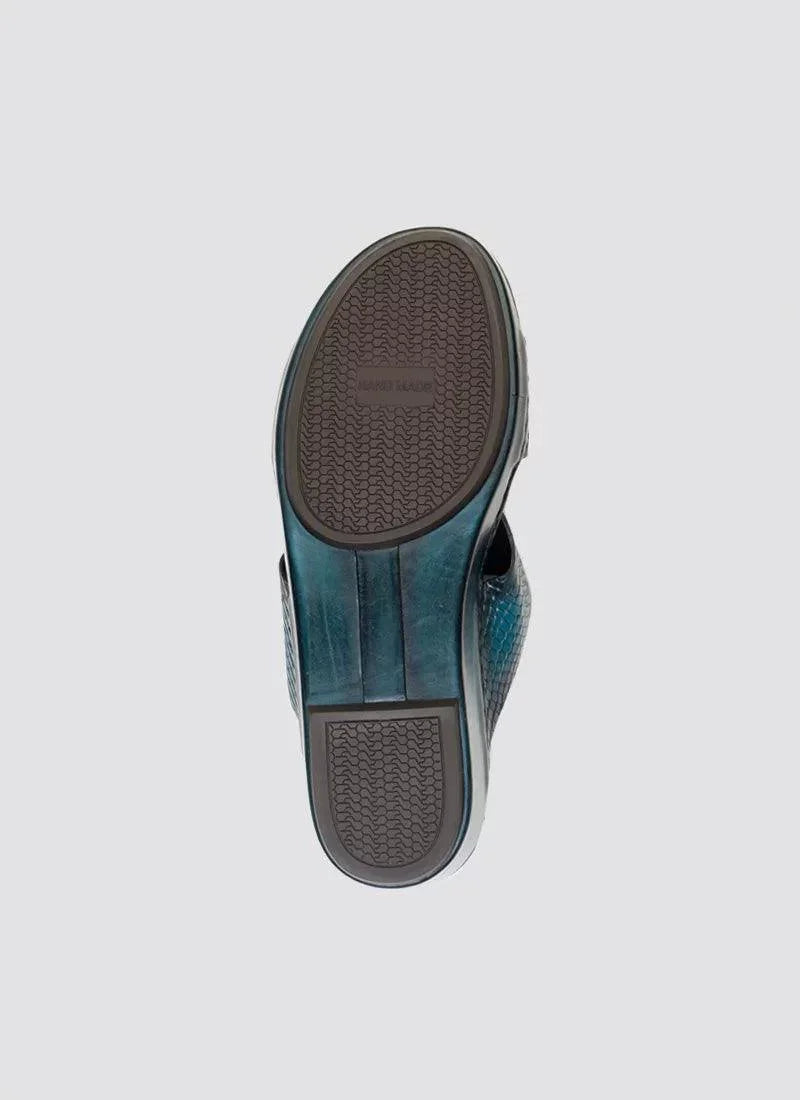 Close-up of turquoise textured men's loafer shoe sole on light background