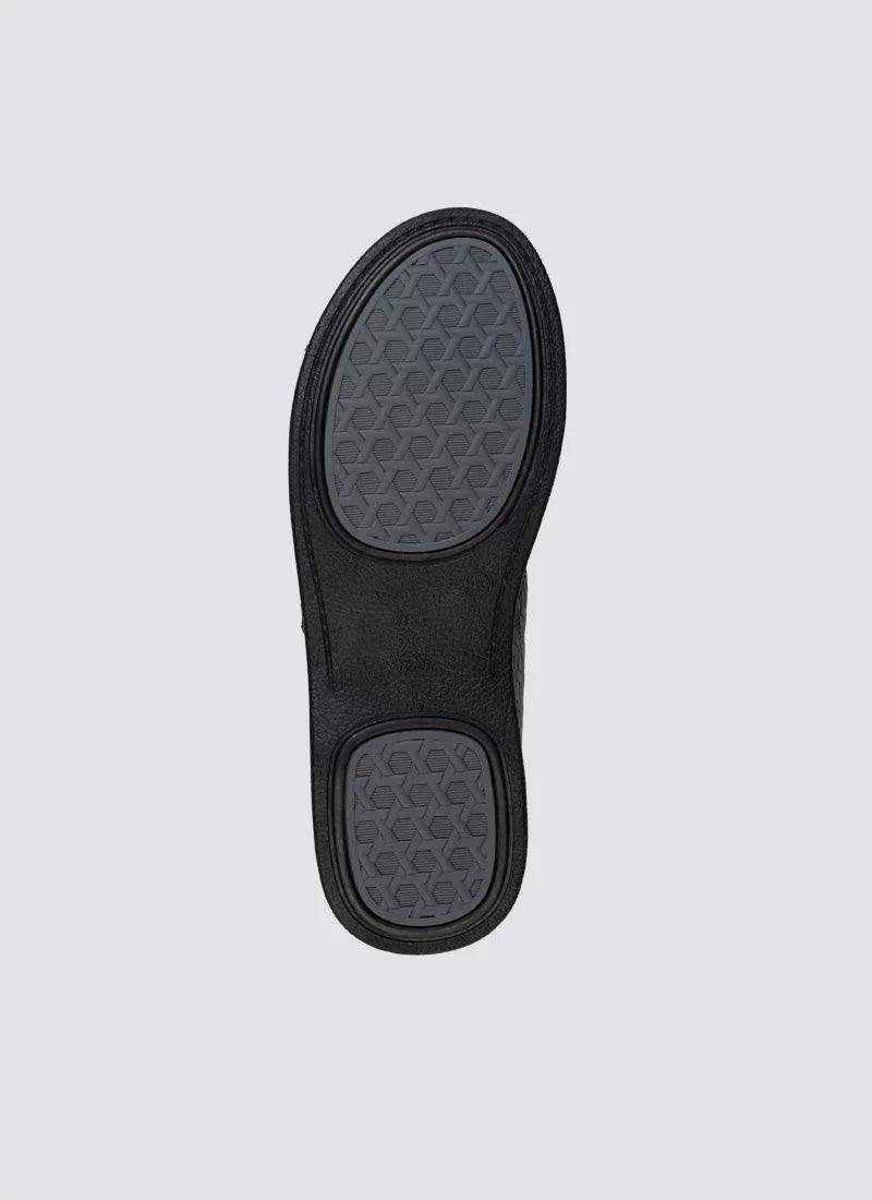 Black shoe sole with textured hexagonal grip design on a light background