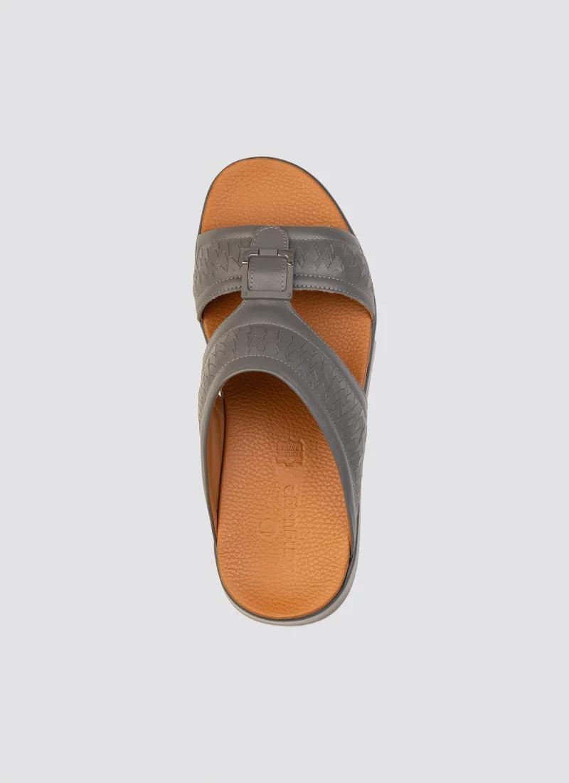 Top view of a grey leather men's sandal with textured crisscross straps and tan insole.