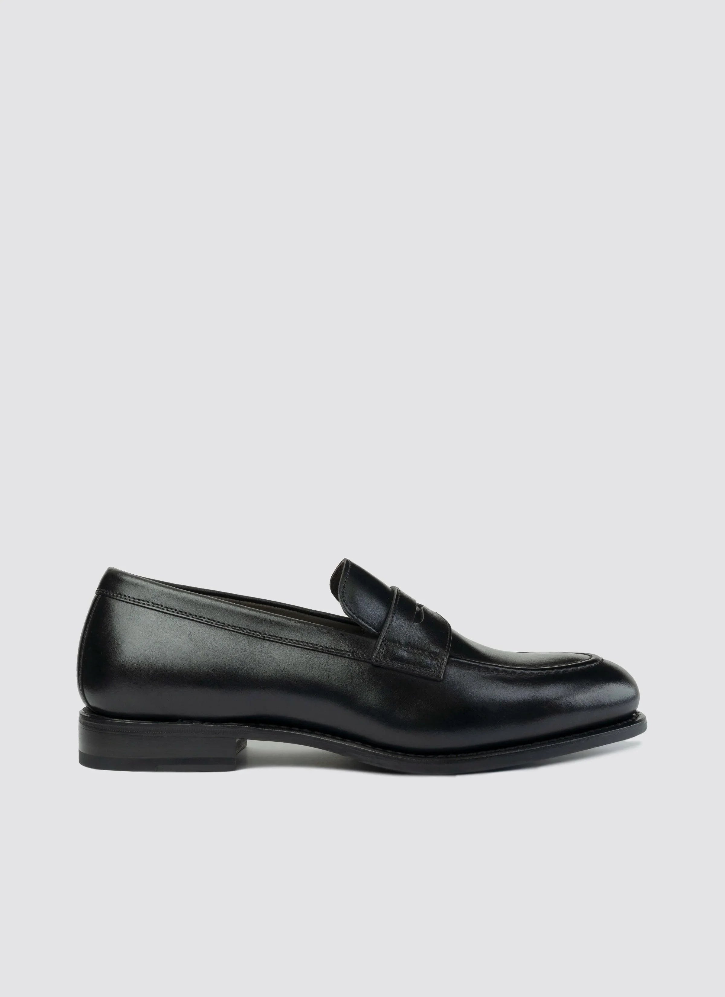 Black leather men's loafer with penny strap, classic formal shoe on white background #color_black