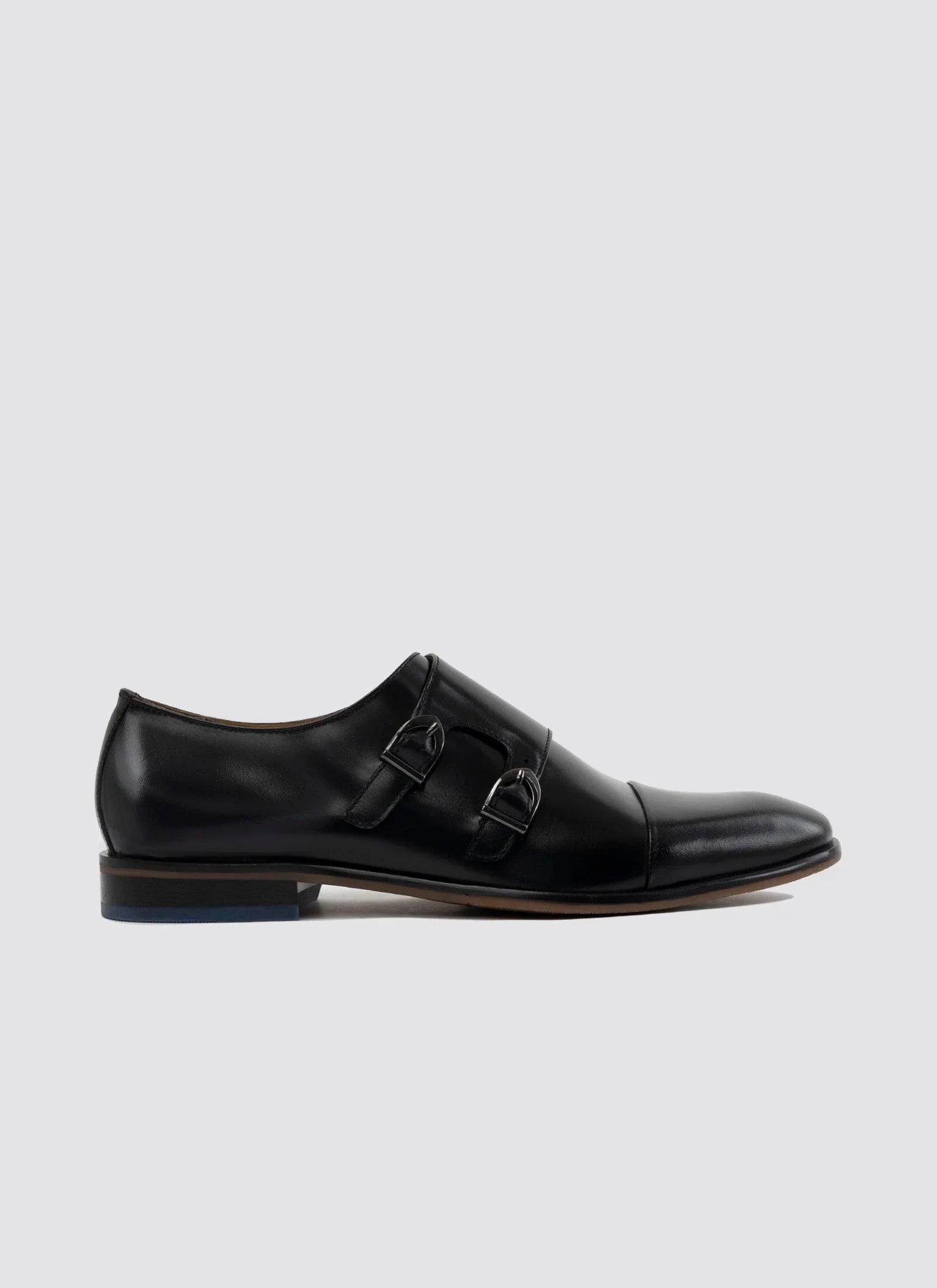 Men's black leather double monk strap dress shoe with cap toe on light background