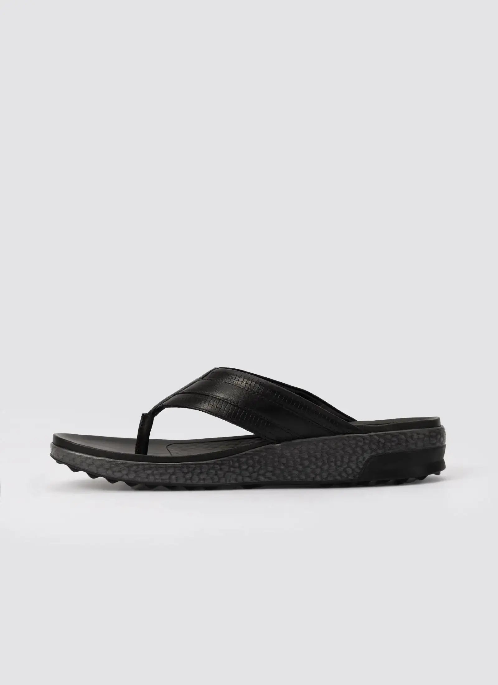 Black men's leather thong sandal with textured sole on white background