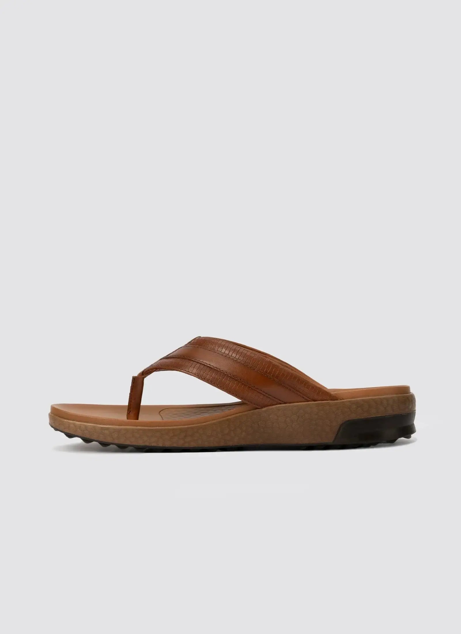 Men's tan brown leather flip-flop sandal with textured sole, side view on white background.