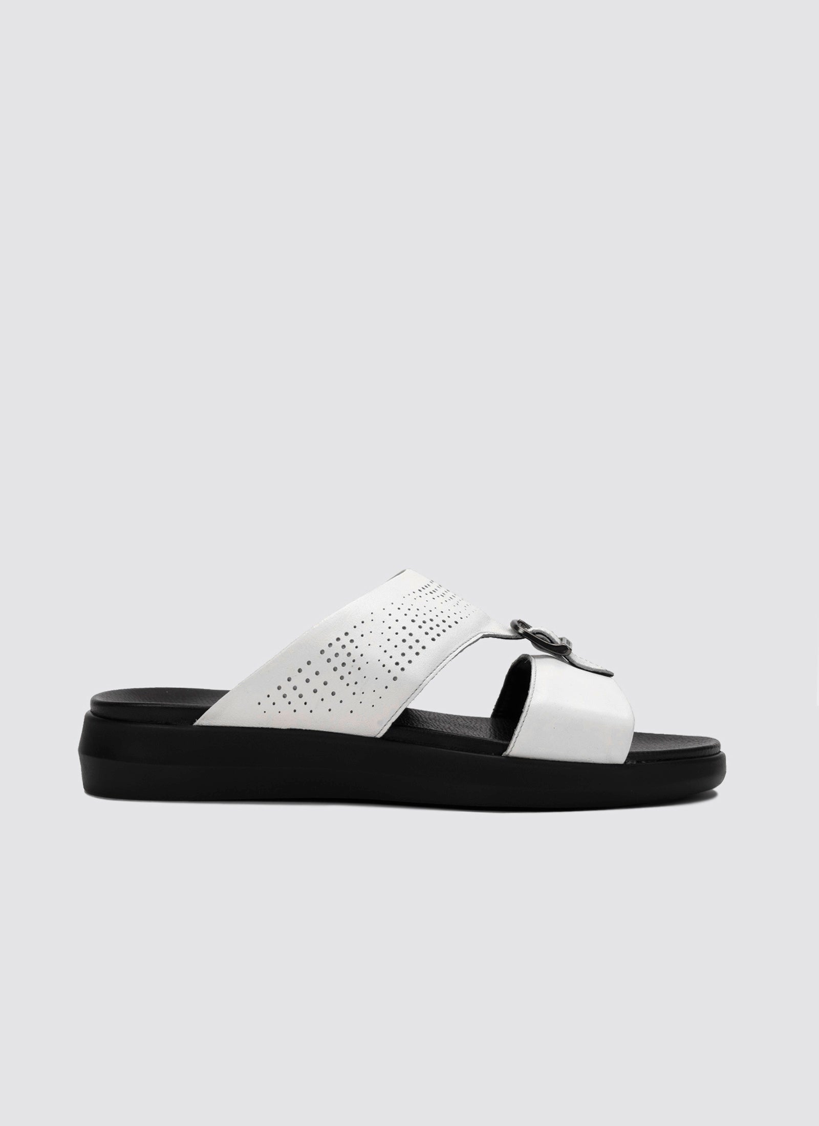 White sandal with black sole on a light gray background