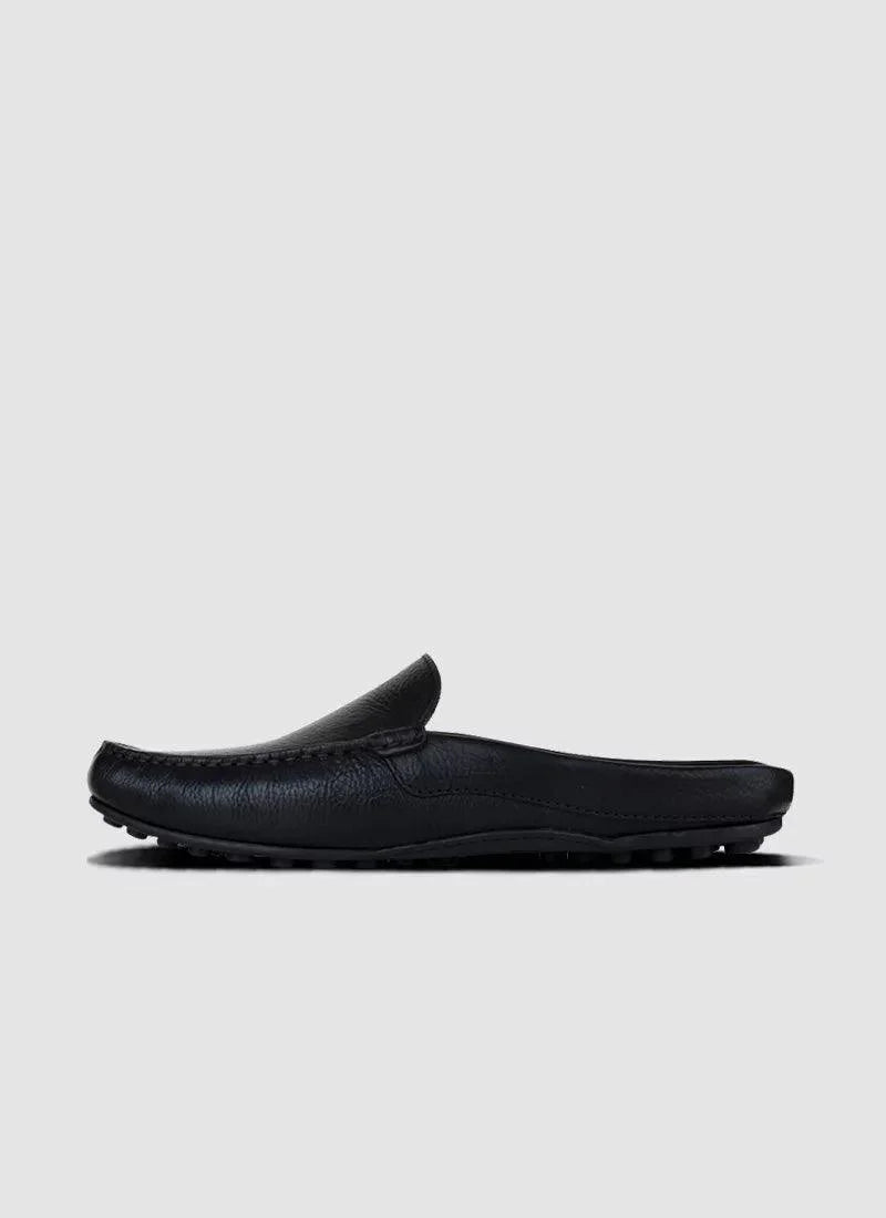 Black leather men's loafer mule with textured sole on a plain grey background