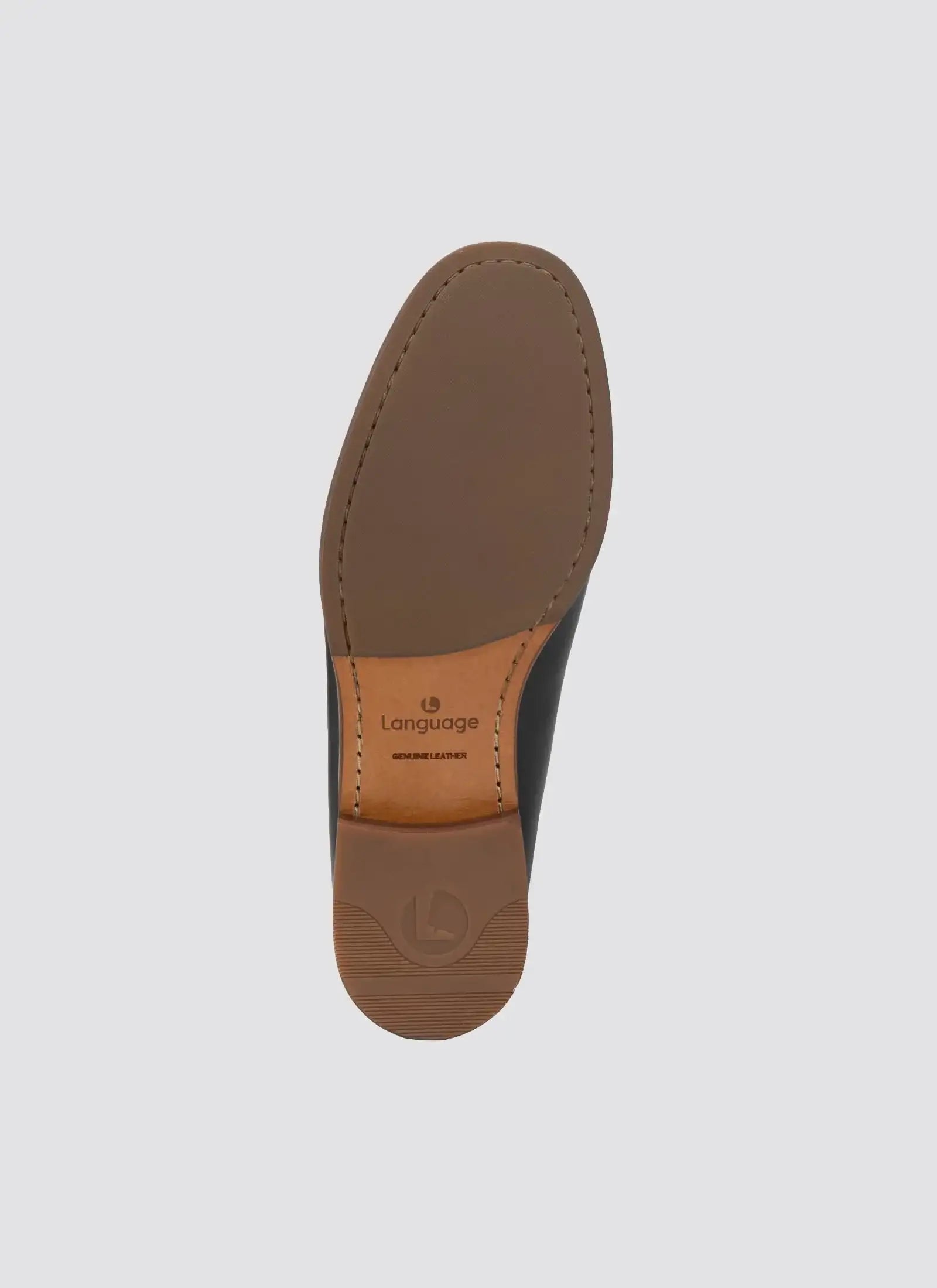 Close-up of brown genuine leather men's shoe sole with branding on light background