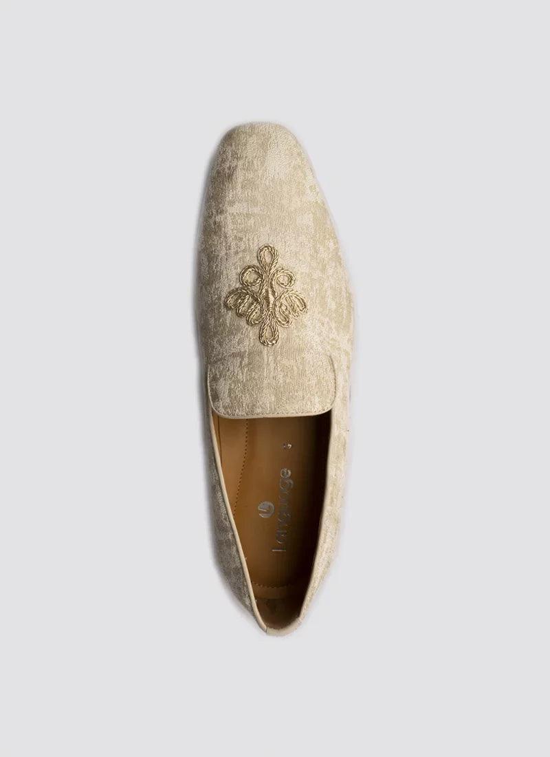 Beige velvet loafer for men with gold embroidery, formal ethnic footwear on plain background