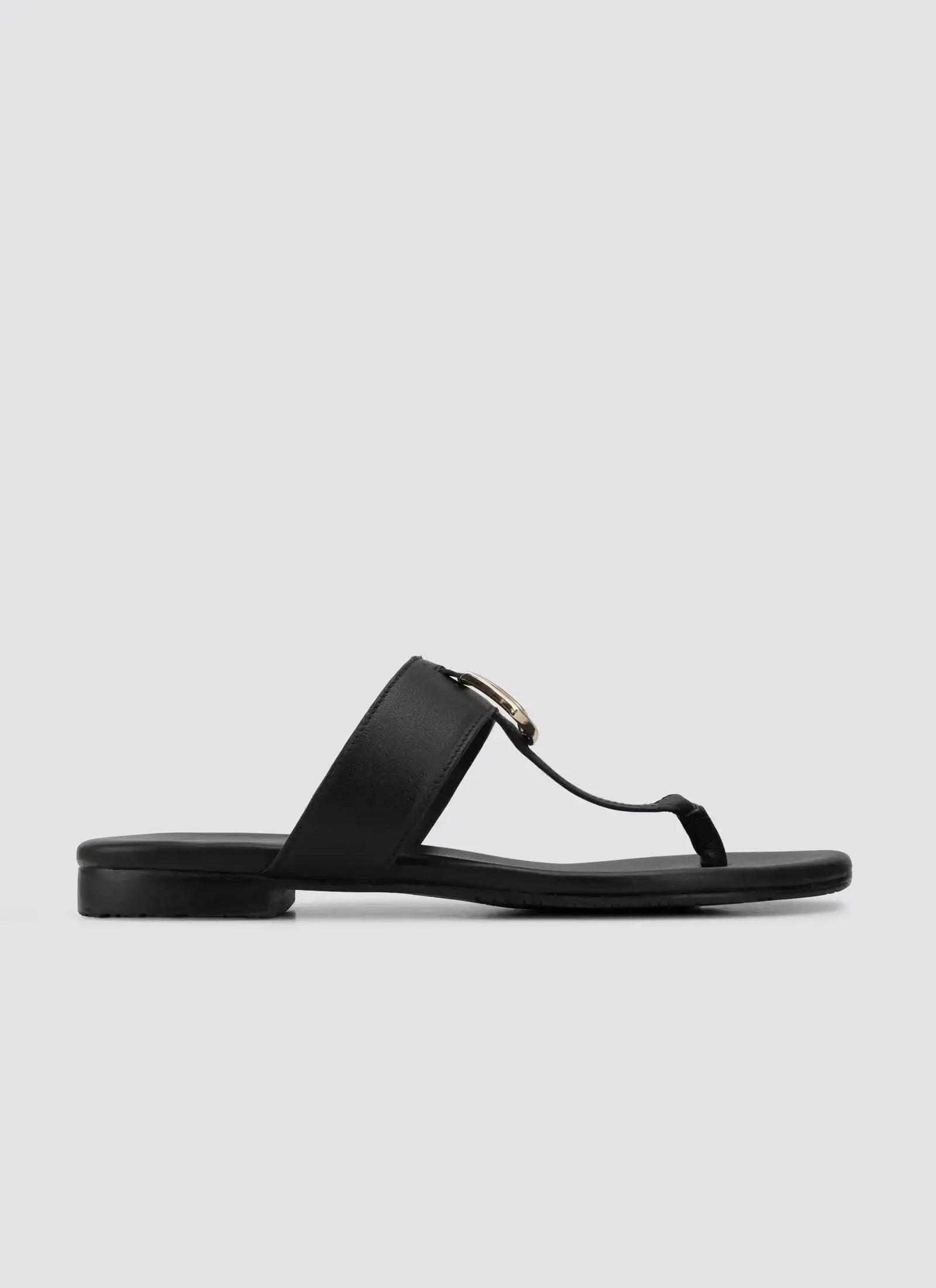 Black leather flat sandal for women with wide strap and metallic accent, side view