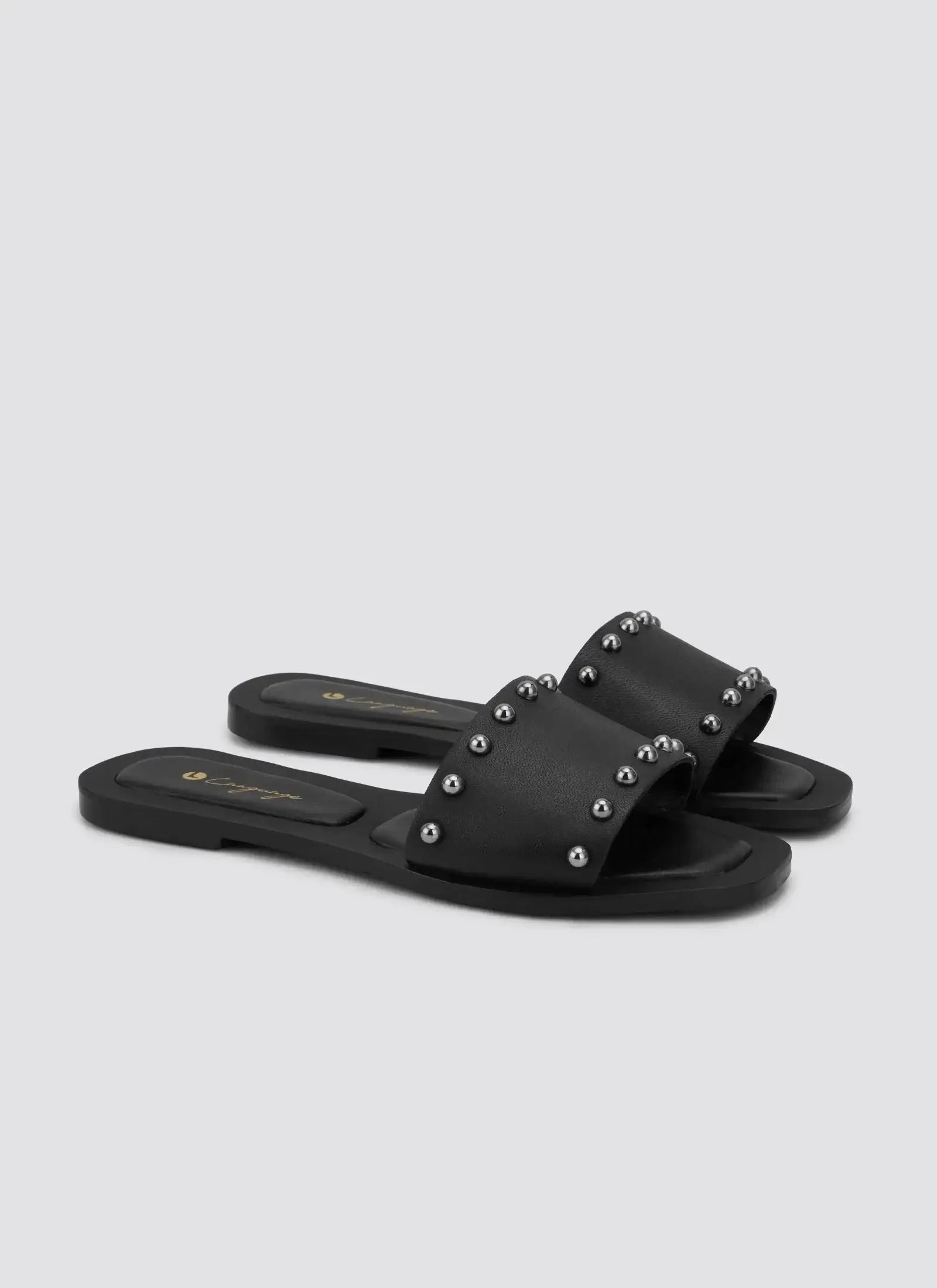Black flat slide sandals with silver stud detailing for women, side perspective