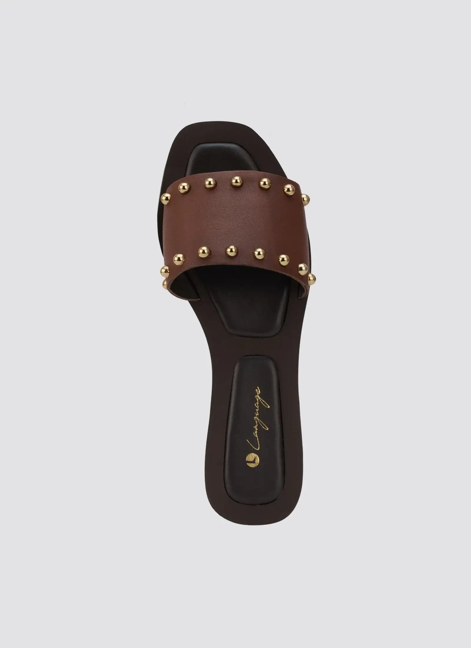 Brown leather slide sandal with gold studs and black sole on white background