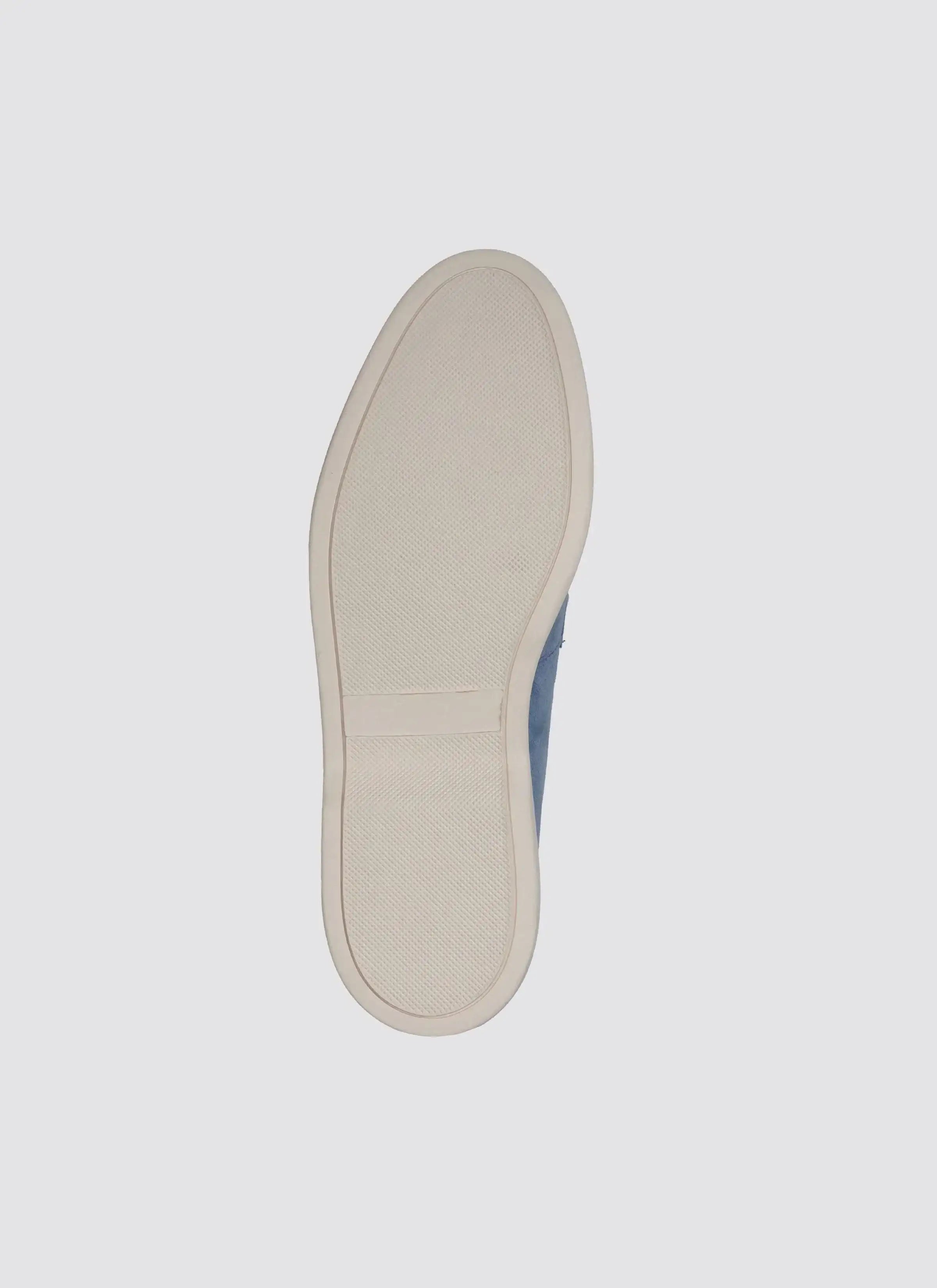 Close-up of a white textured rubber shoe sole on a light background
