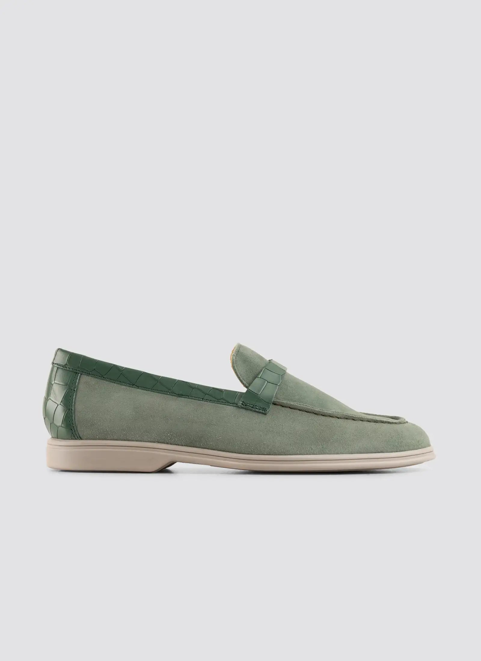 Green loafer shoe on a light gray background