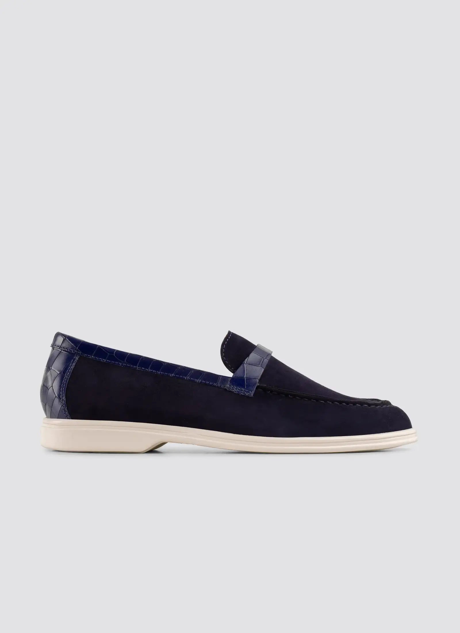 Navy blue loafer shoe on a light gray background