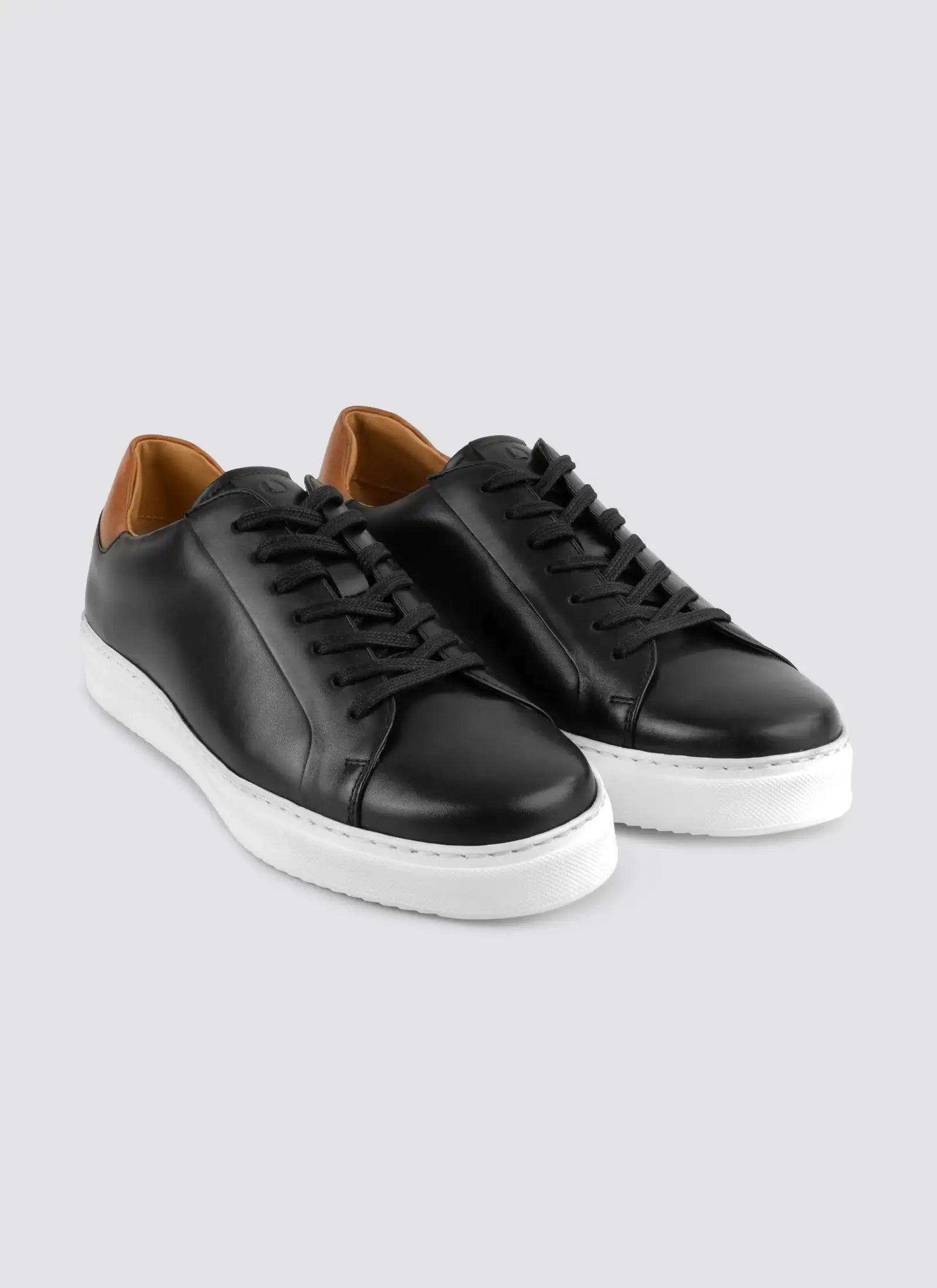 Black sneakers with white soles on a light gray background #color_black