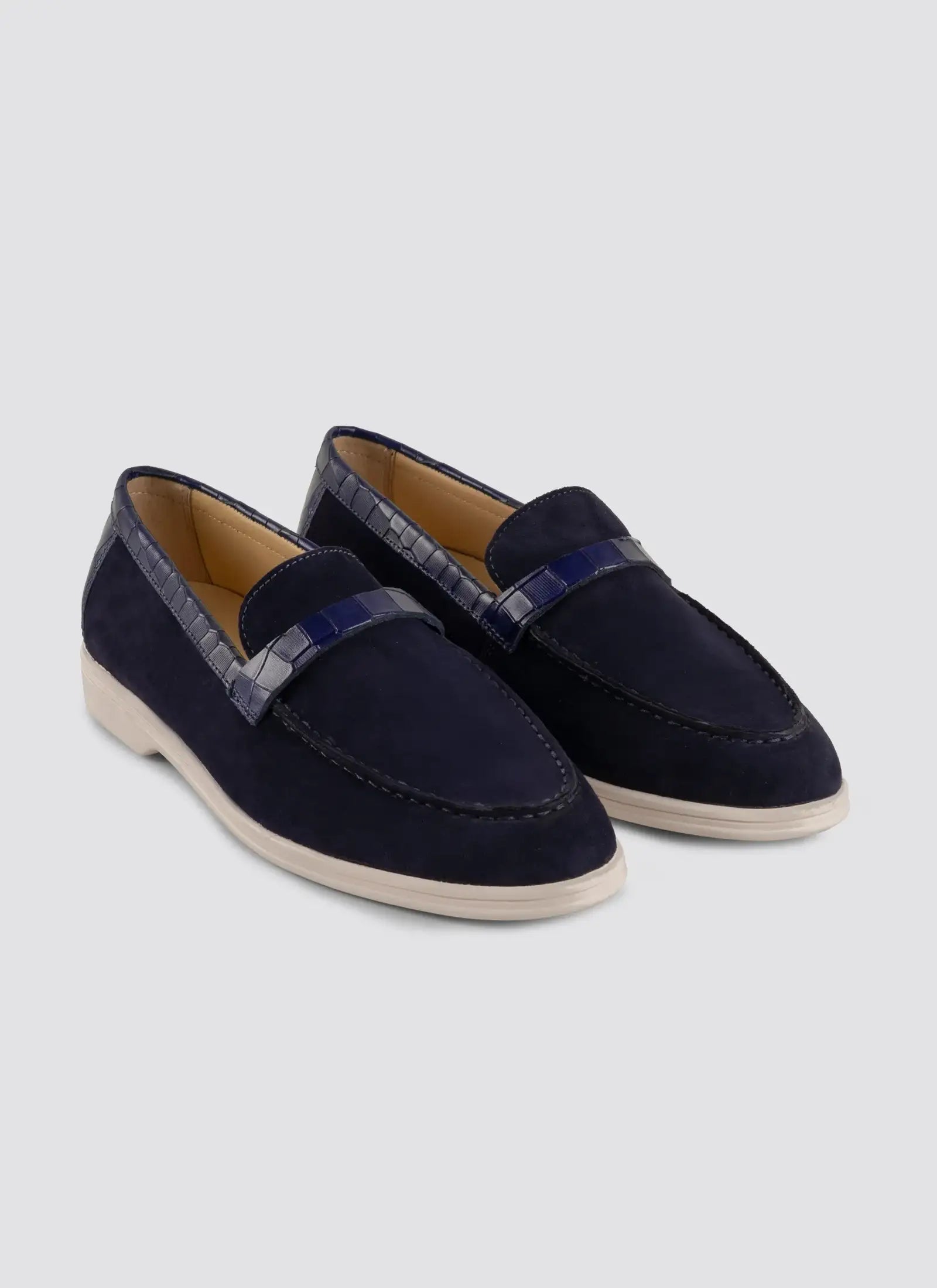 Pair of navy loafers on a light gray background