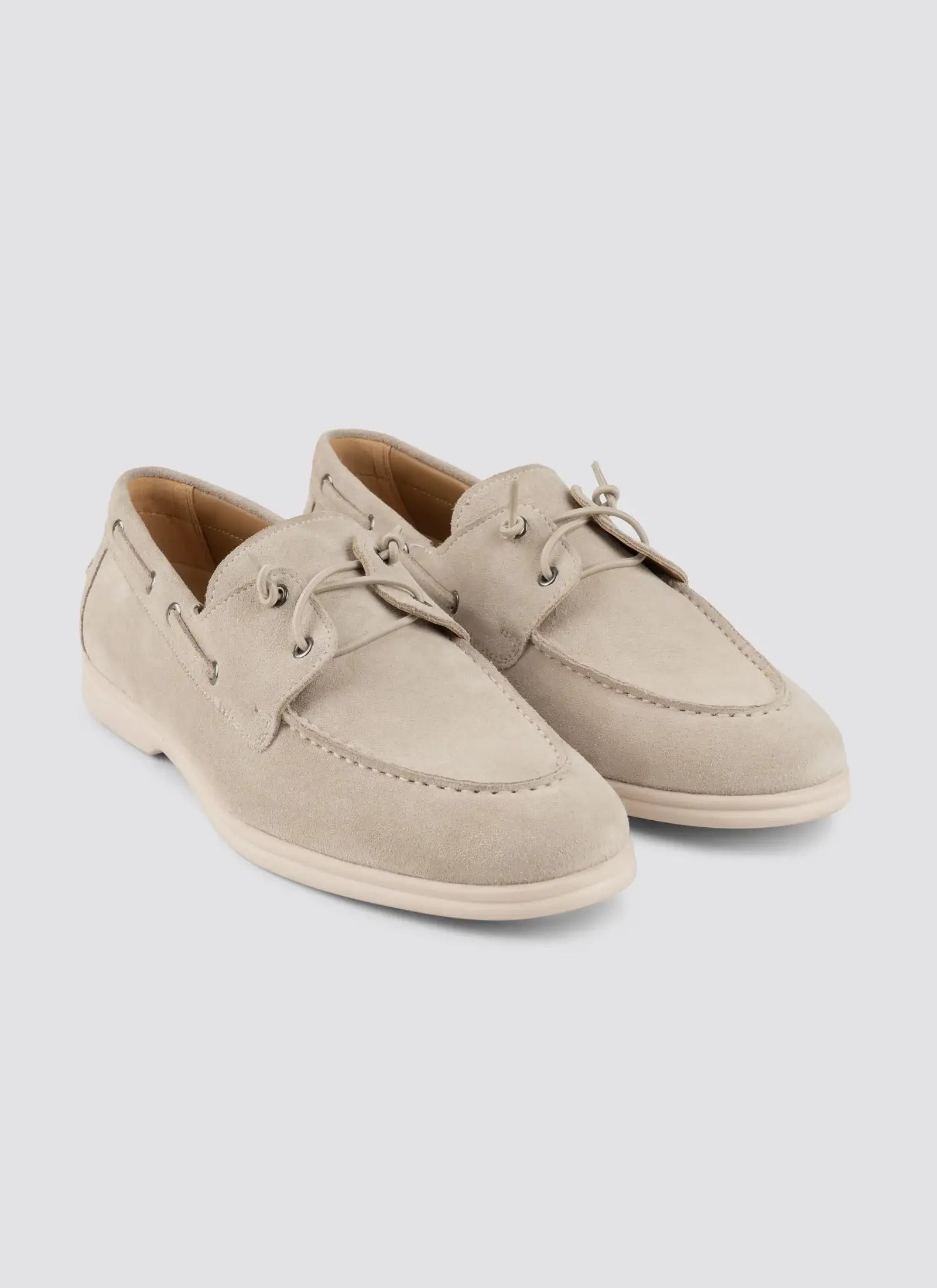 Pair of beige suede men's loafers with lace detail on a white background #color_beige
