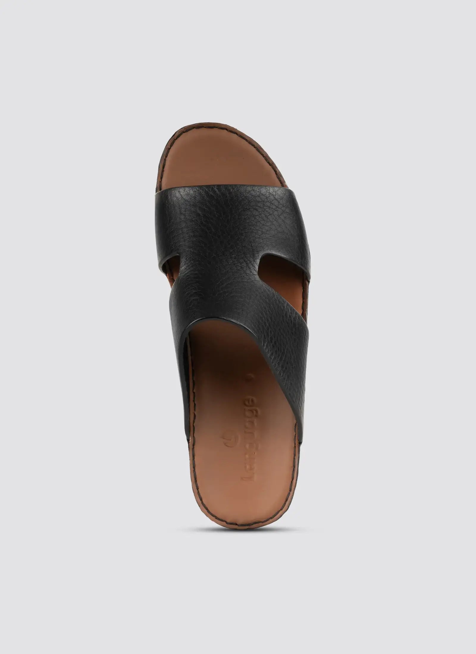 Black sandal with brown sole on a light gray background