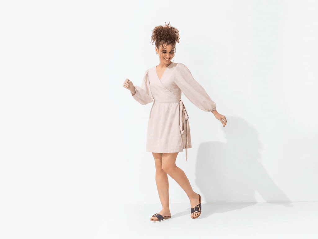 Woman in light dress wearing black open-toe sandals, stylish women's footwear on white background