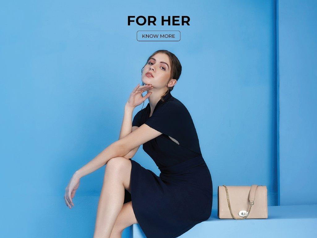 Woman in navy dress with beige handbag, stylish women's accessories on blue background