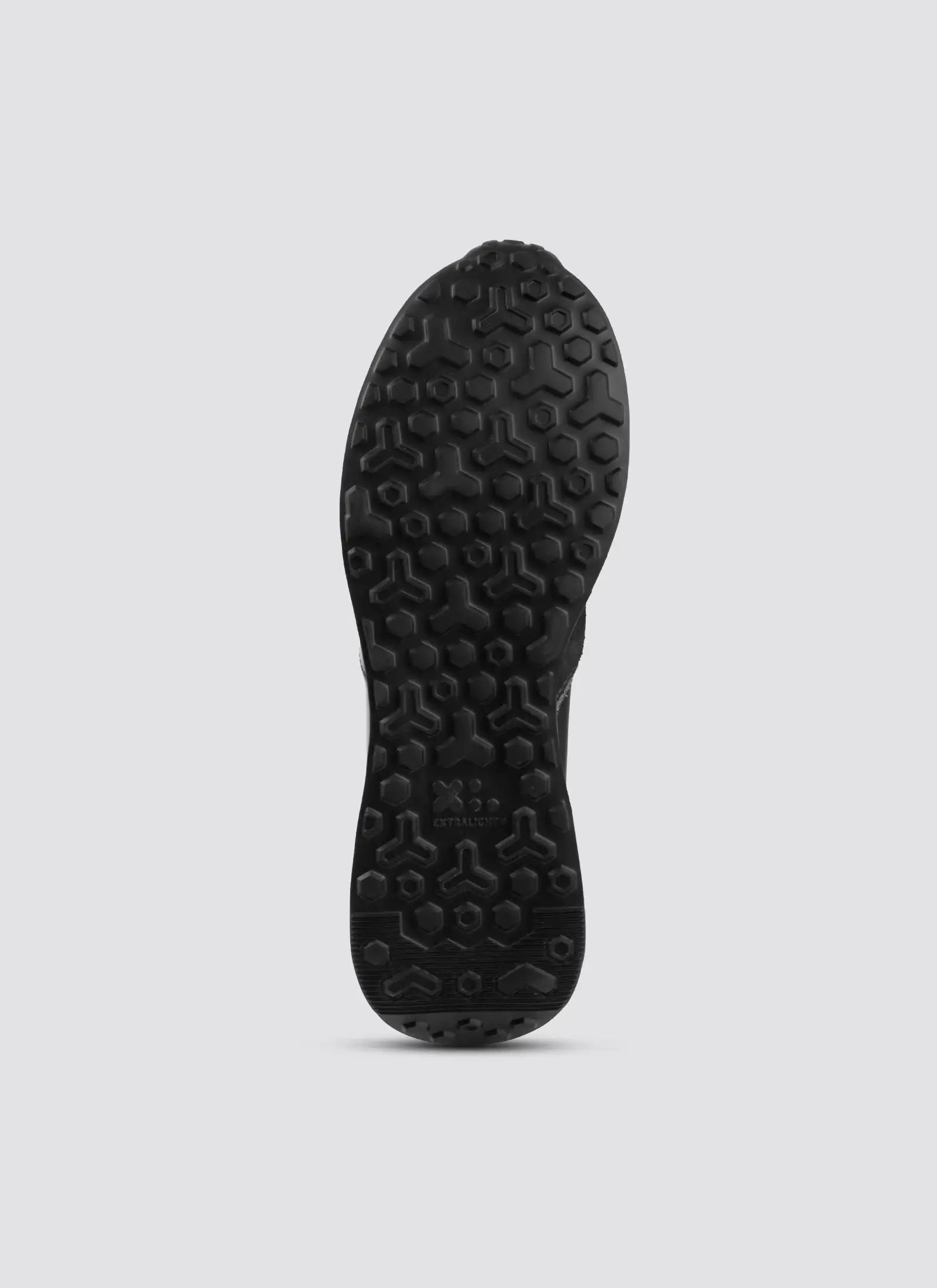 Black shoe sole with textured, hexagonal tread pattern on a light background 
