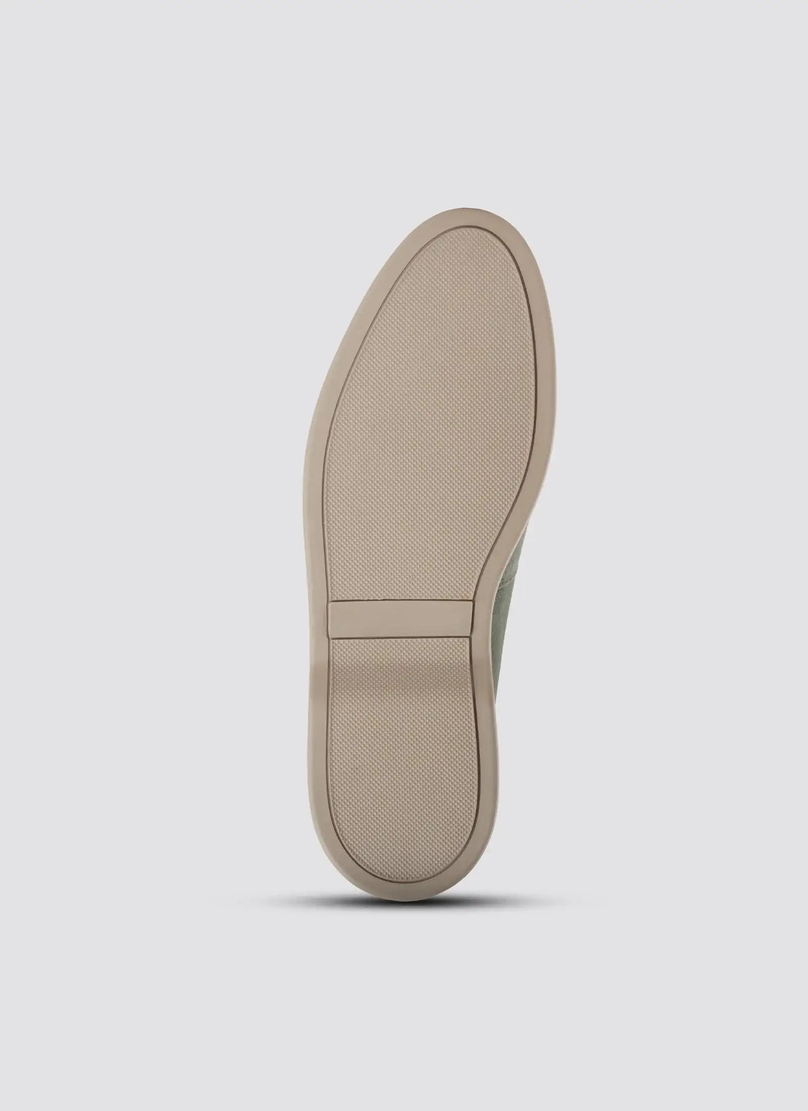 Close-up of a beige shoe sole on a light gray background 