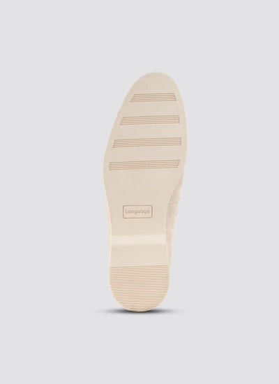 Beige dress shoe sole with grooves and rectangular embossed branding on light background 
