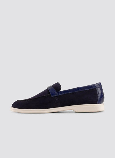 Navy blue loafer shoe on a light gray background 