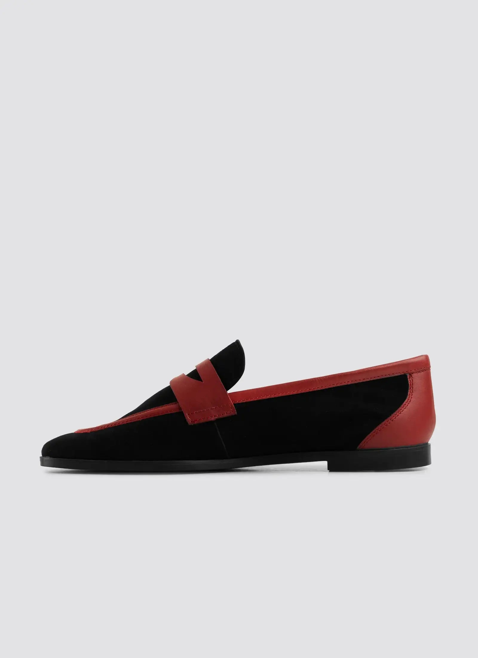 Black and red loafer shoe on a light gray background  