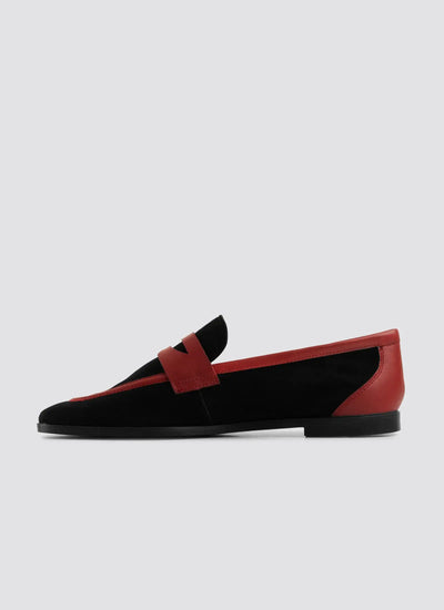 Black and red loafer shoe on a light gray background  
