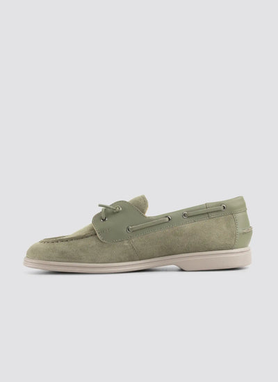 Green boat shoe on a light gray background 